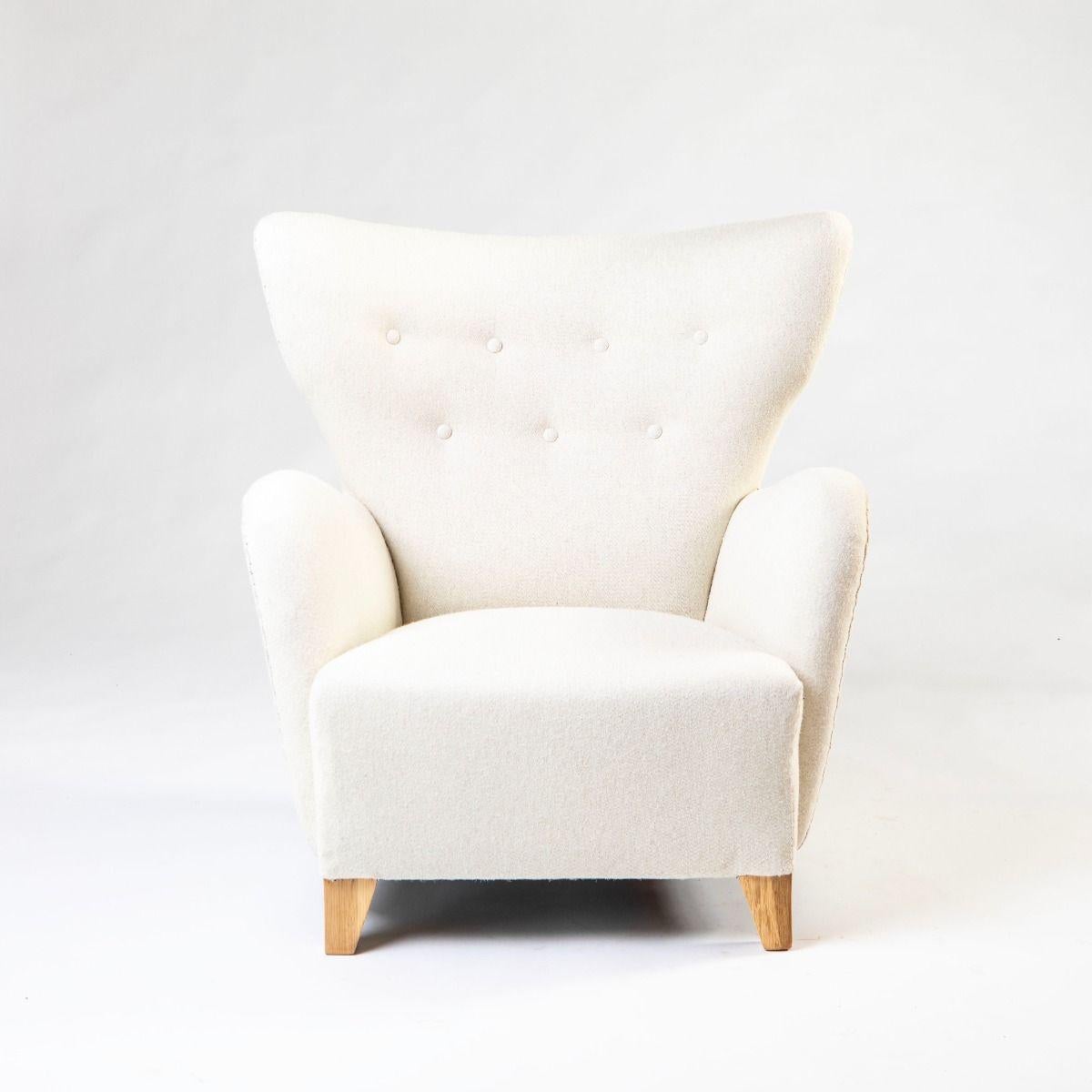 Chaise longue élégante aux formes organiques, conçue par Jens Houmøller Klemmensen vers 1940 et fabriquée par Skive Møbelfabrik.
Le profil sculptural de la chaise se caractérise par un dossier légèrement incurvé et des accoudoirs arrondis, créant