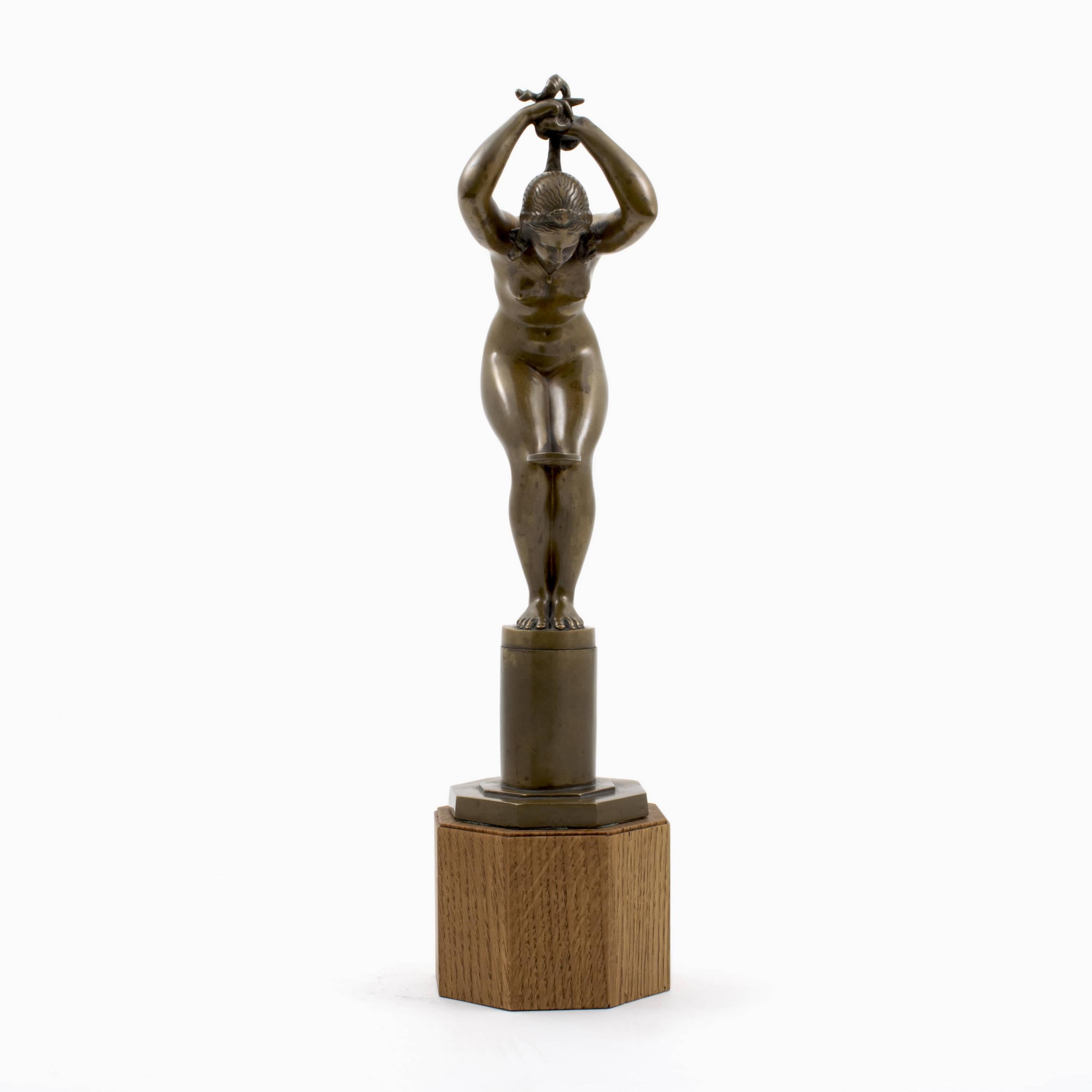 Jens Jacob Bregnø (dänisch 1877-1946).

Patinierte Bronzeskulptur einer nackten Frau, die ihr Haar flechtet und einen Spiegel zwischen den Knien hält.
Auf dem Sockel signiert JJB.

Hergestellt von L. Rasmussen, Kopenhagen ca. 1930.
Auf