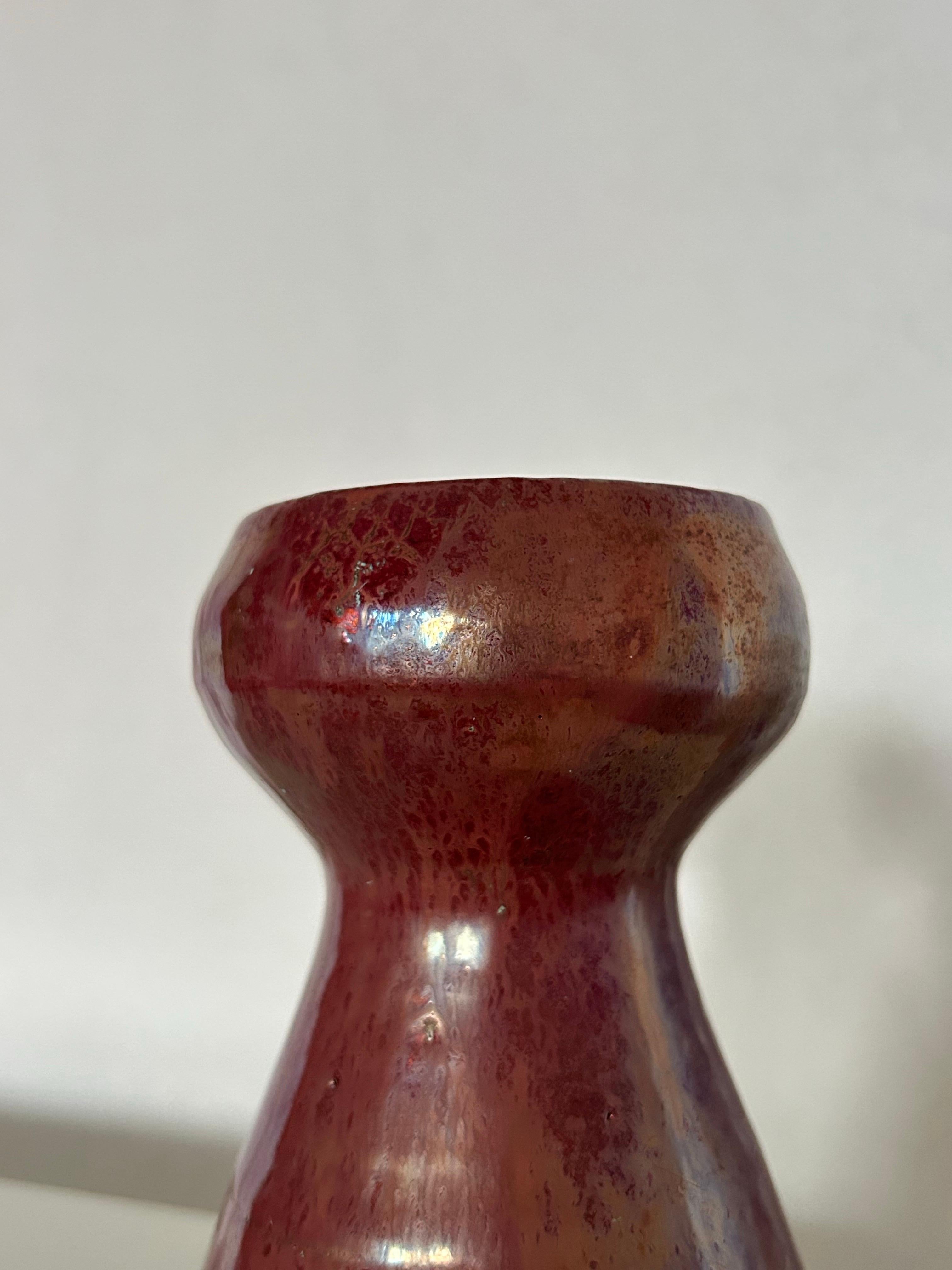 Vaso in ceramica dell'artista danese Jens Petersen (1890-1956), realizzato con il suo caratteristico smalto rosso metallizzato, rinomato per la sua ricca profondità e la sottile iridescenza. Questo pezzo esemplifica la maestria di Petersen nelle