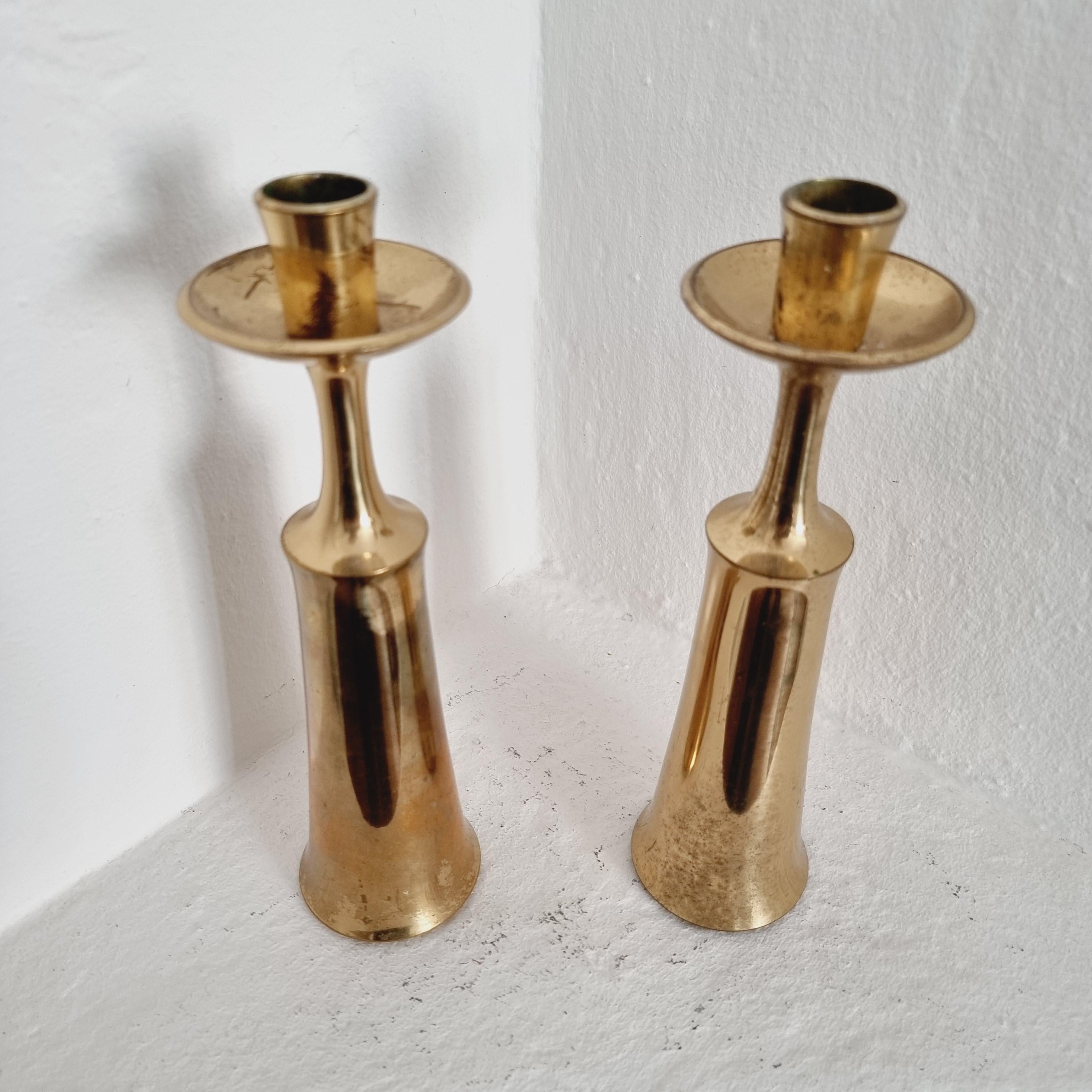 A pair of solid brass candlesticks in an tall, elegant design. By Jens Quistgaard for Dansk Design, Denmark, Midcentury Modern.


Hallmark inside holders. Patina, signs of age and wear. Smaller dents and color shifts.