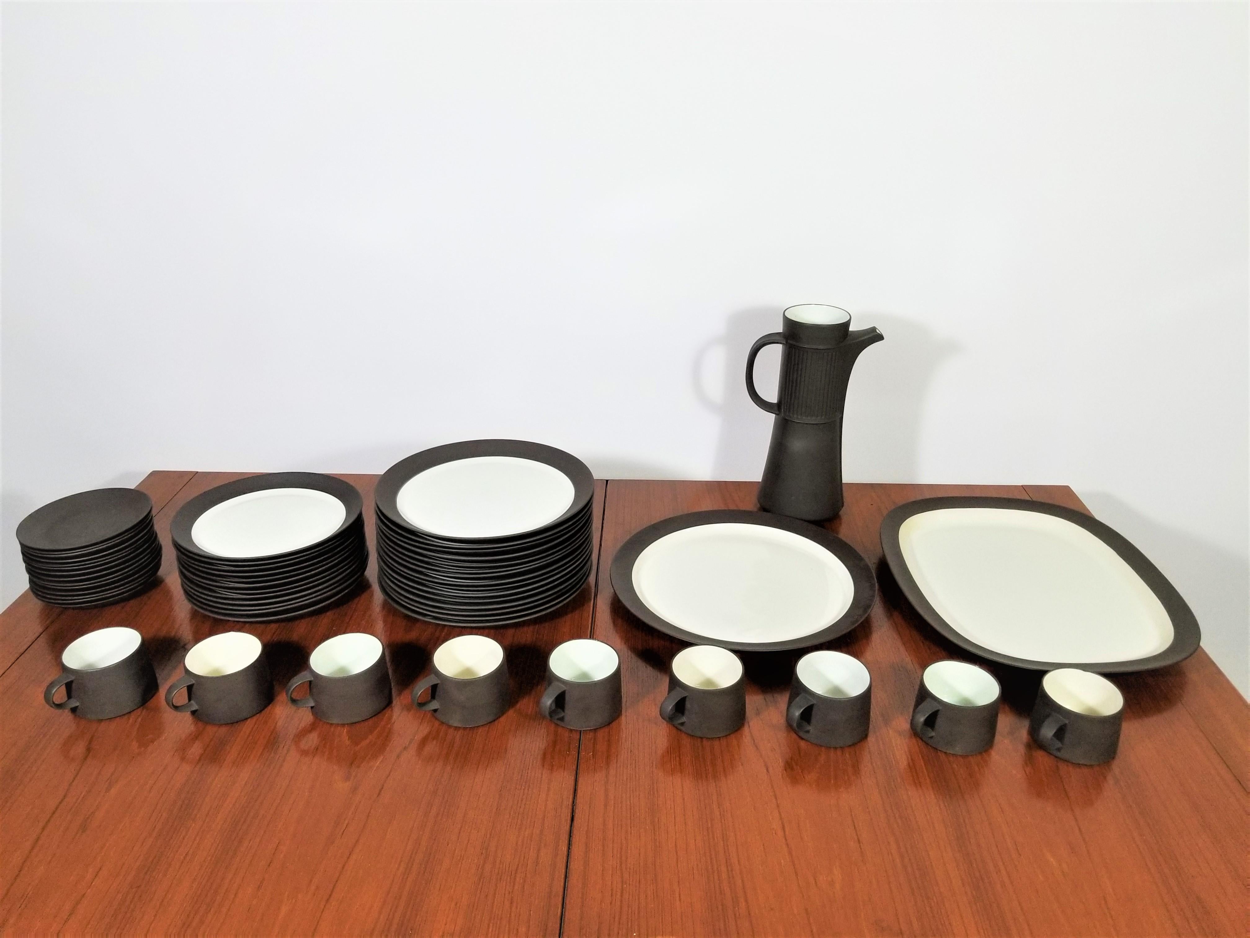 Gorgeous Mid-Century black and white 1960s JHQ Jens Quistgaard for Dansk, Denmark flamestone dinnerware serving set. 53 pieces total. All pieces are marked and in exceptional excellent condition.
Complimentary free delivery can be arranged for this