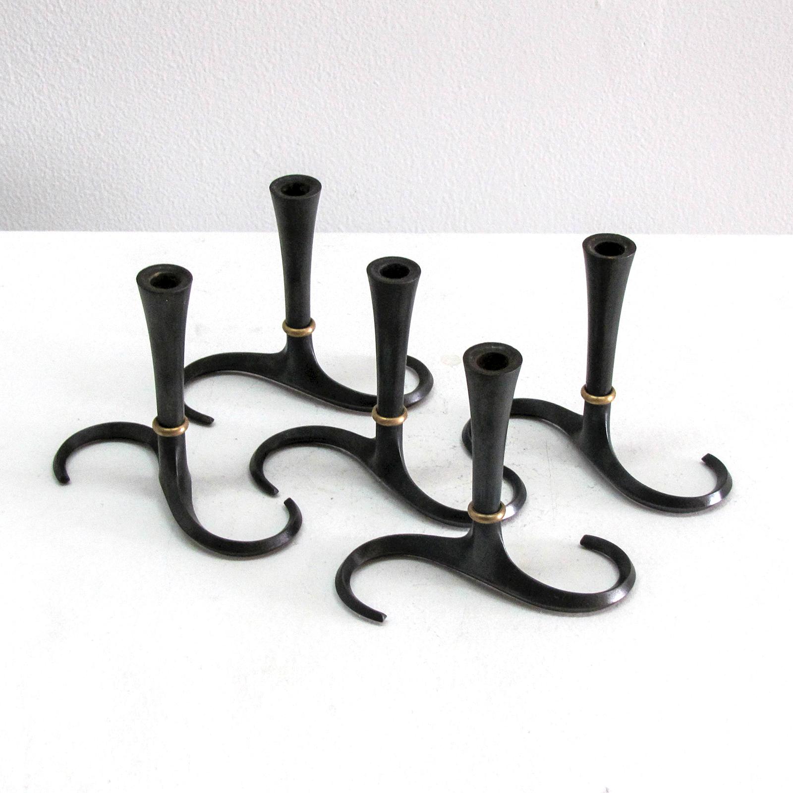 Elegant set of five cast iron candleholders by Jens Quistgaard for Dansk, black patina with brass accents, one candleholder stamped.