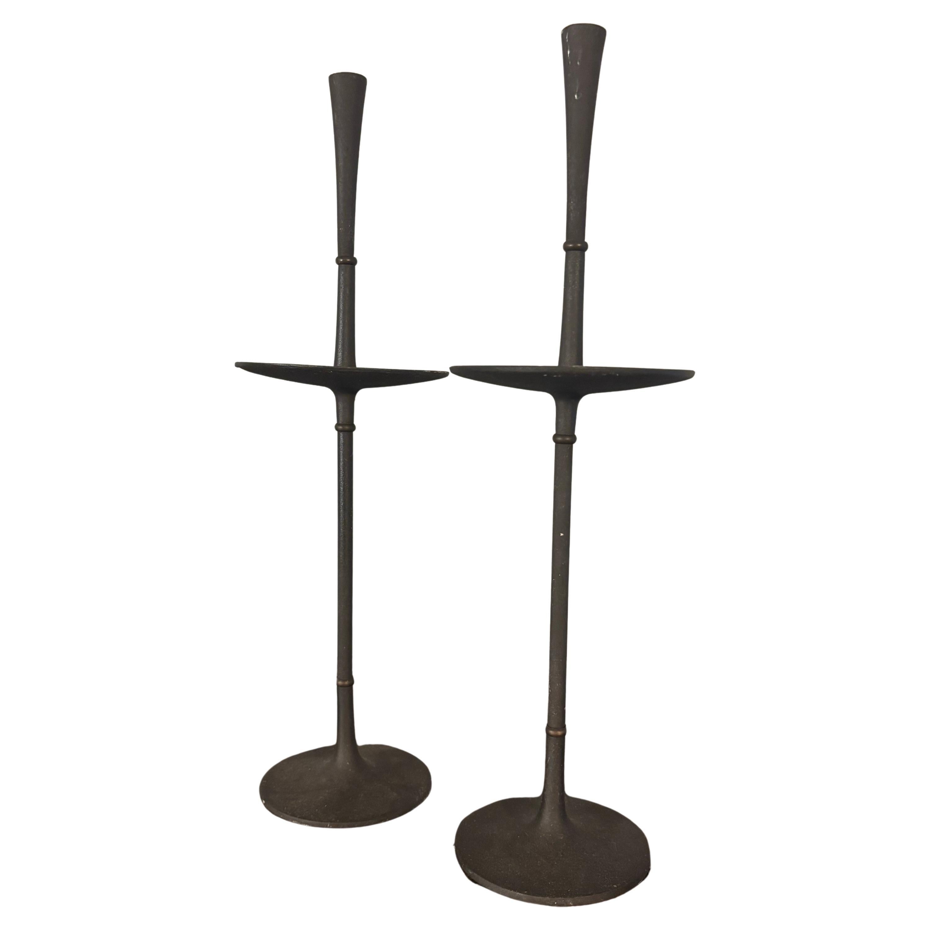 A rare pair of elegant Dansk cast iron and brass candlestick holders designed by Jens Quistgaard in the 1960s. Made up of 4 sections that screw together with a brass divider between each piece. Both are incised on the bottom of the base with 