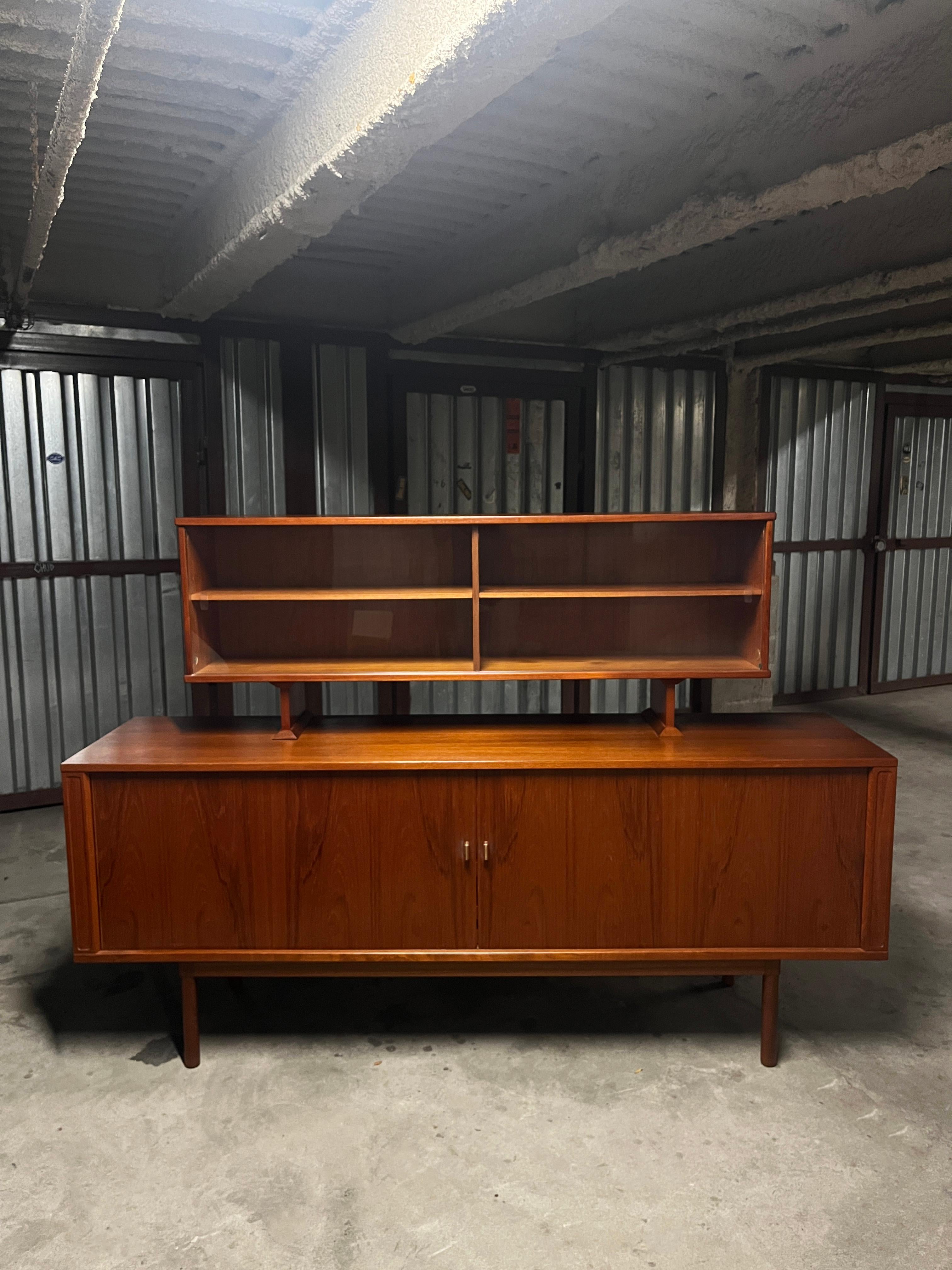 This is one stunning tambour door teak Danish Mid-Century Modern credenza with glass door hutch by Jens Quistgaard for Peter Løvig Nielsen. Signed and dated 1973 underneath. Outfitted with four sliding drawers on the center of the piece flanked by