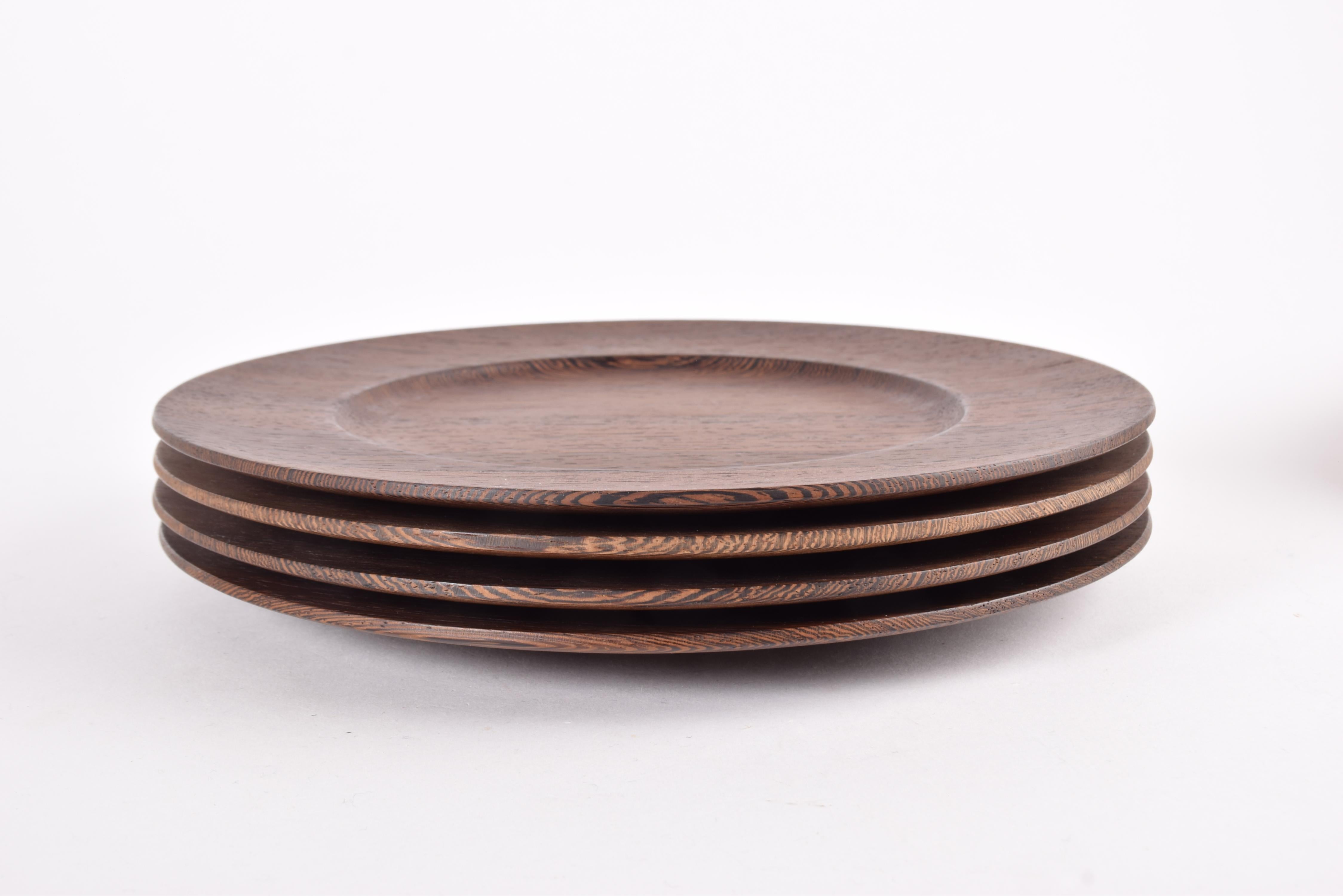 Set of 4 coaster plates by Danish designer Jens Harald Quistgaard. Manufactured for Kronjyden by Nissen ca 1960s. 

The plates are made from solid Wengé, a rare wood with a beautiful grain and dark color.

Marked on back with a golden stamp from