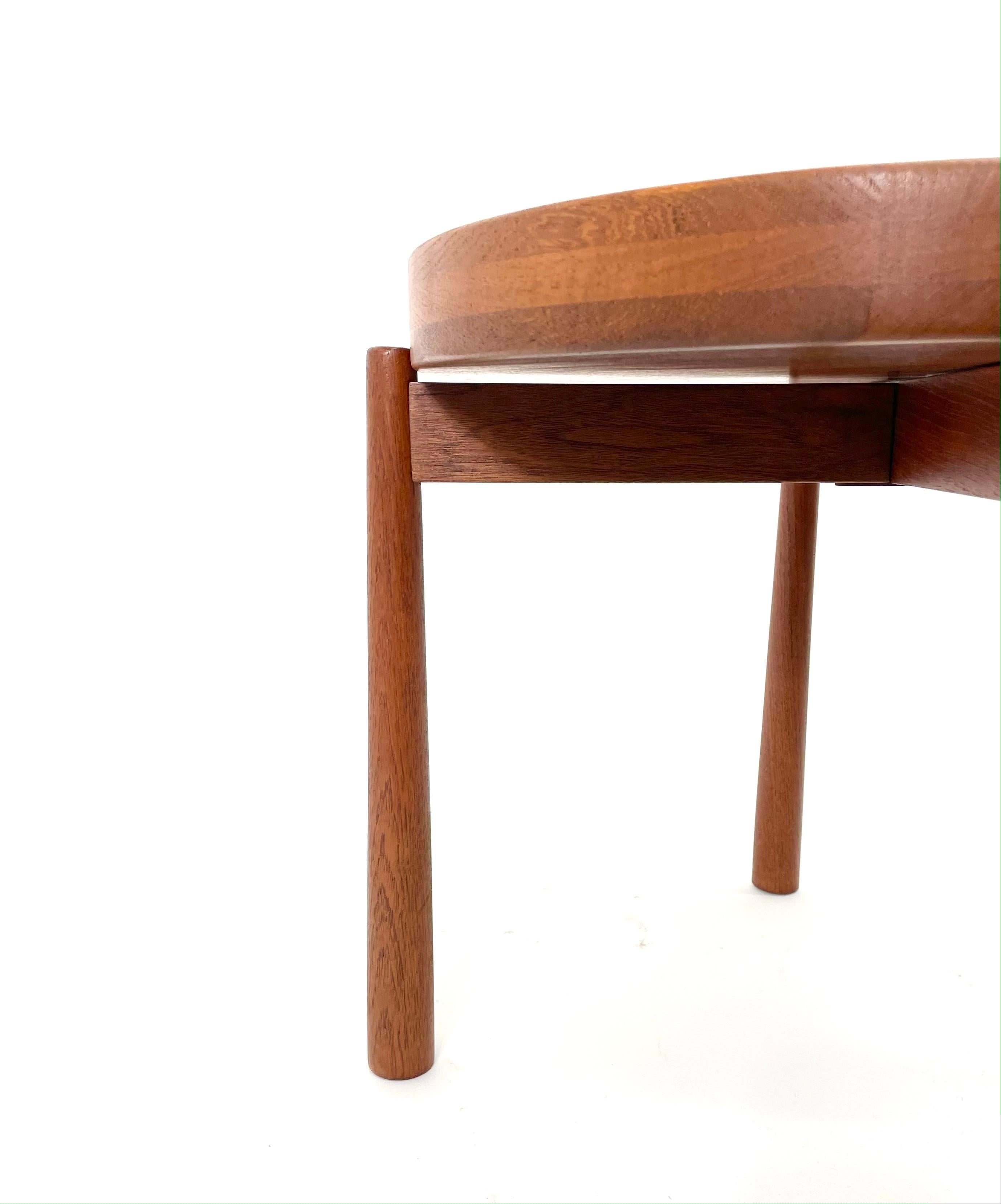 Beautiful side table designed by Jens Harald Quistgaard for DUX, 1950s, in teak. 
We have two available. Price is per table.

The exquisitely shaped wood top can be removed and used a tray or function as a decorative bowl, with one side being flat