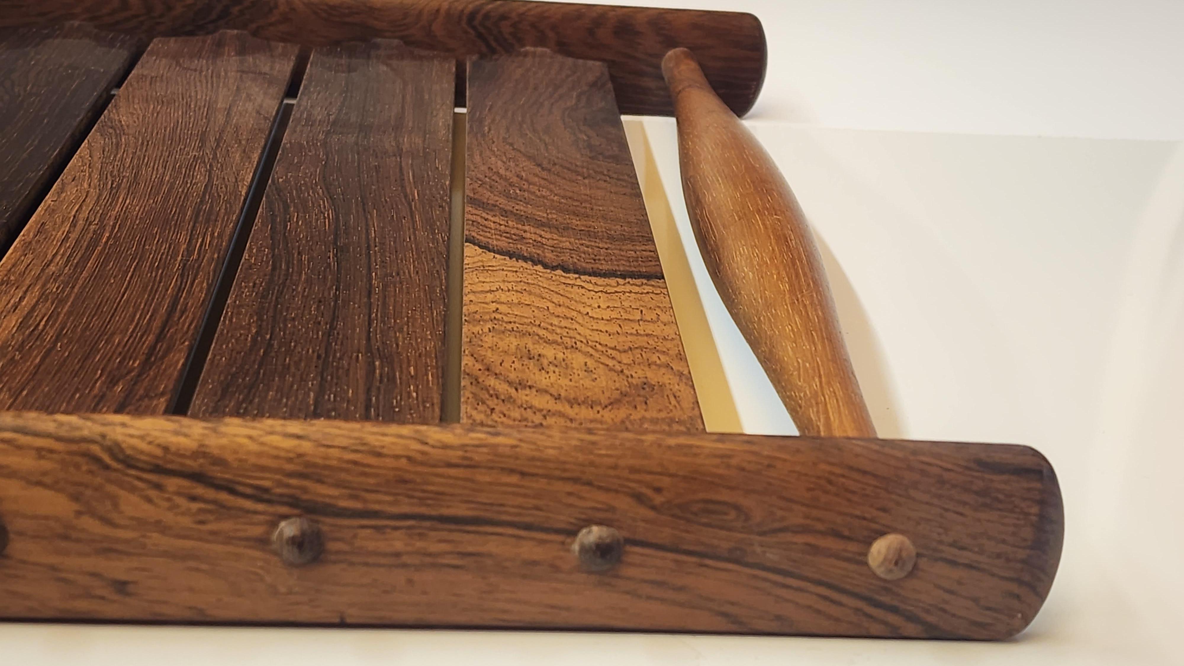 Wonderful desirable and rare Slatted Brazilian Rosewood Tray by Jens Quistgaard from his Rare Woods series of objects.   Composed of 10 arrow type slats with curved backs all constructrd using finger tenon's mortised through the end rails which hold