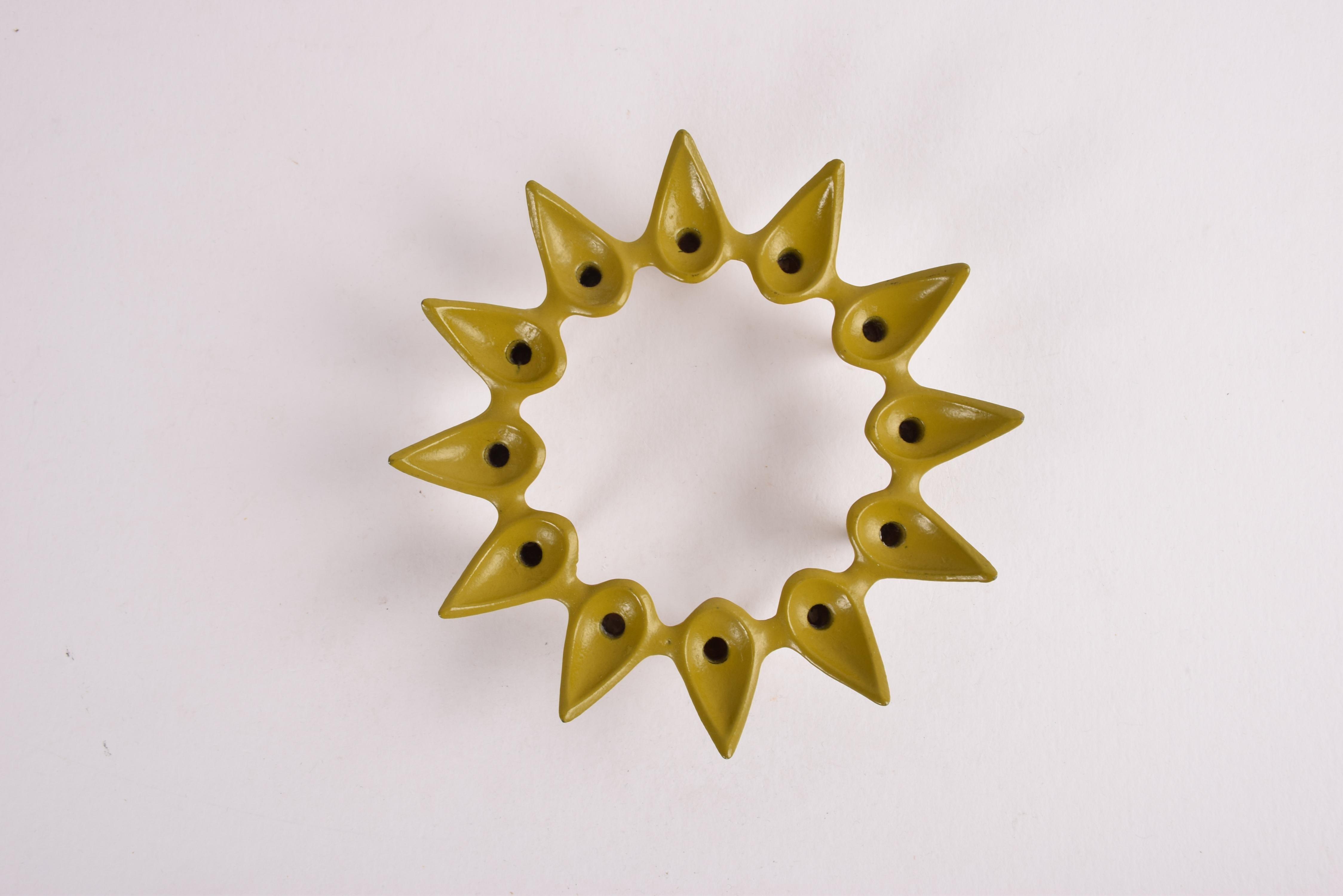Danish Mid-Century Modern candle holder designed by Jens Harald Quistgaard for Dansk Internationals Ltd, USA. Made 1960s.

This is rare version with yellow green lacquer. It's made from cast iron and holds 12 slim candles. 

Very good vintage