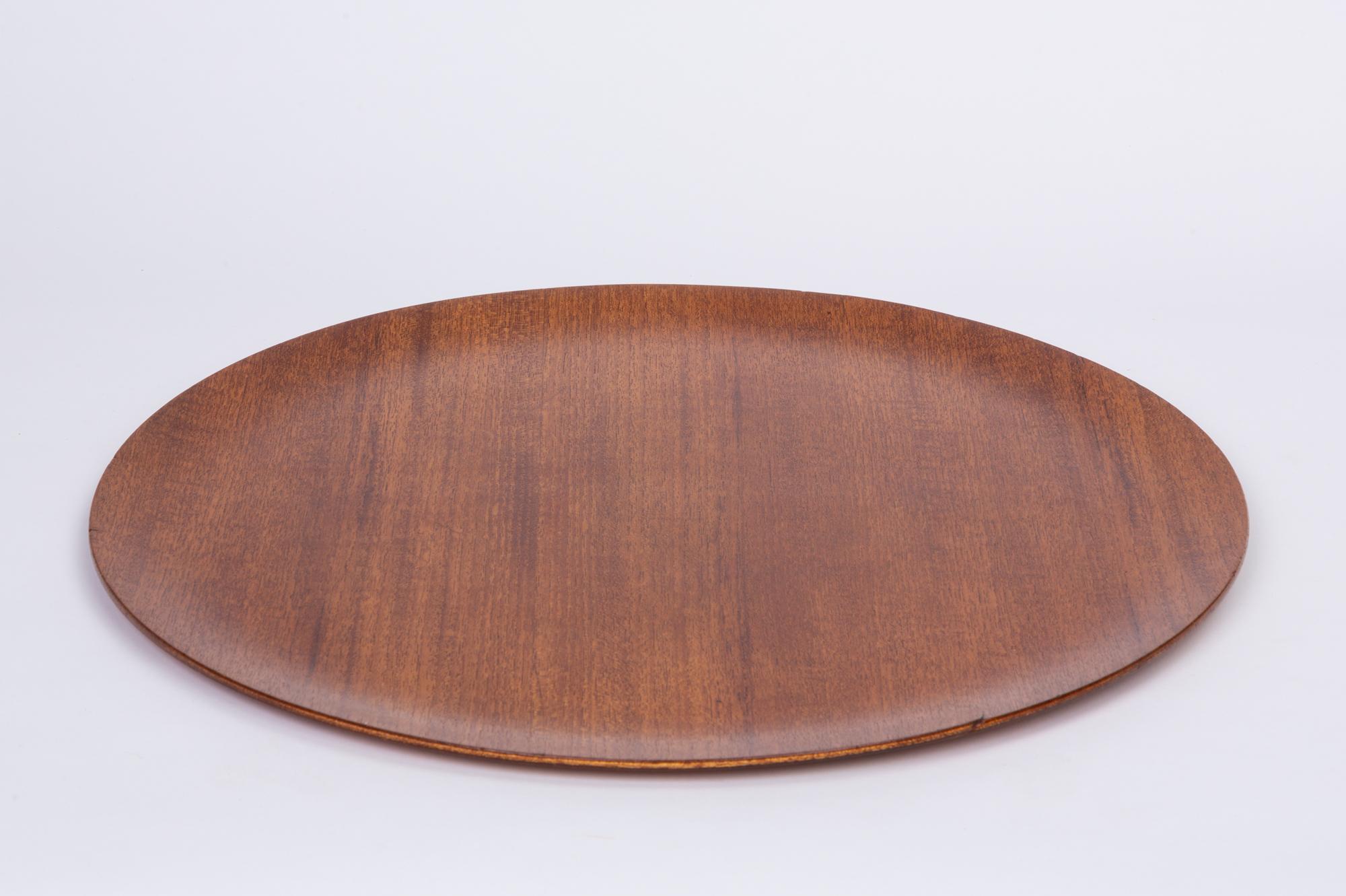 Round teak serving tray in the style of Jens Quistgaard. The tray features a flat edge and beautiful grain that is more apparent with the hand applied oil finish.

Dimensions: 18” diameter x .5” height

Condition: Excellent vintage condition;