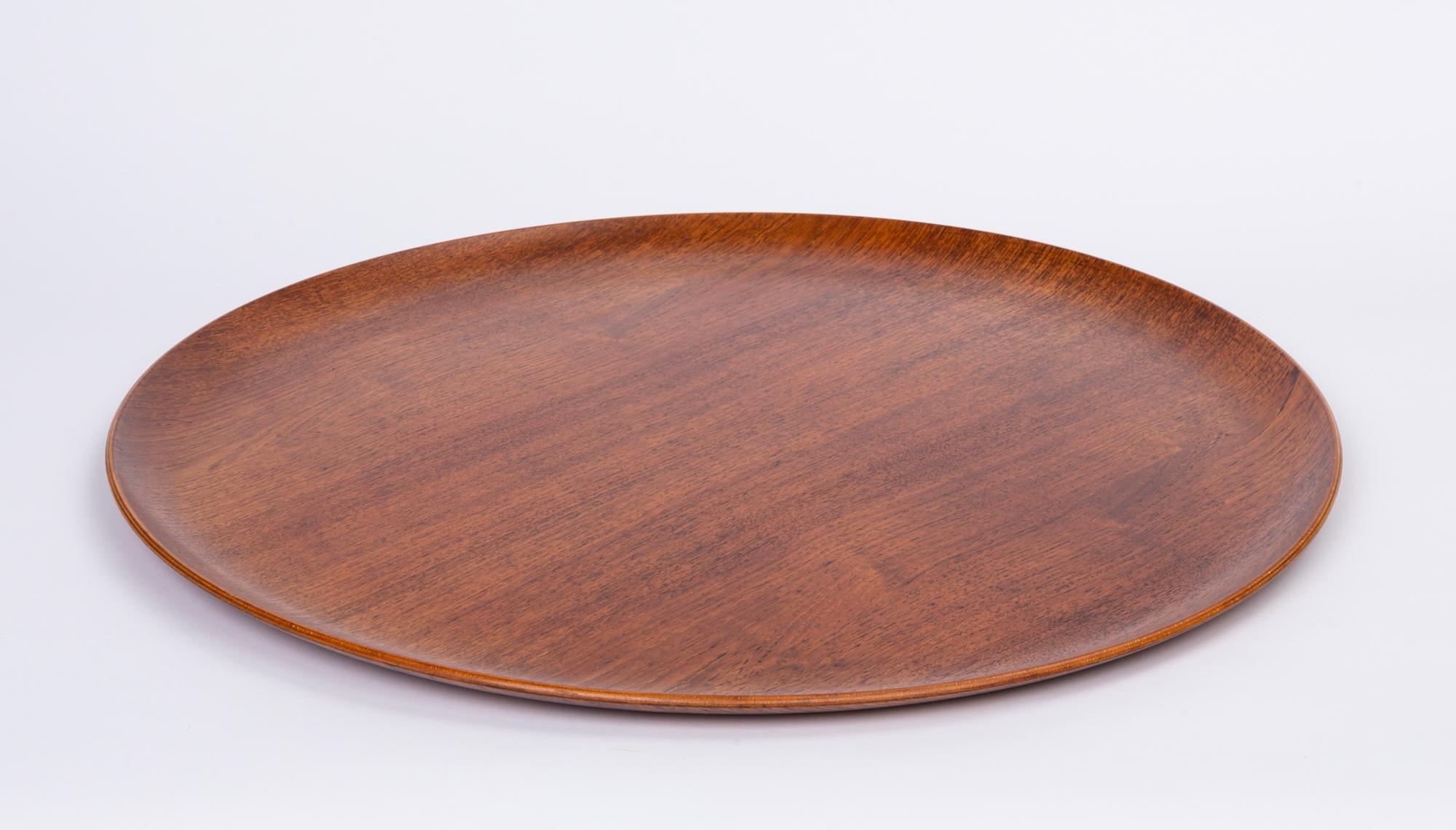 Round teak serving tray in the style of Jens Quistgaard. The tray features curved raised edges and beautiful grain that is more apparent with the hand applied oil finish. Marked on underside [Danish Furniture Makers Control]

Dimensions: 23.5”
