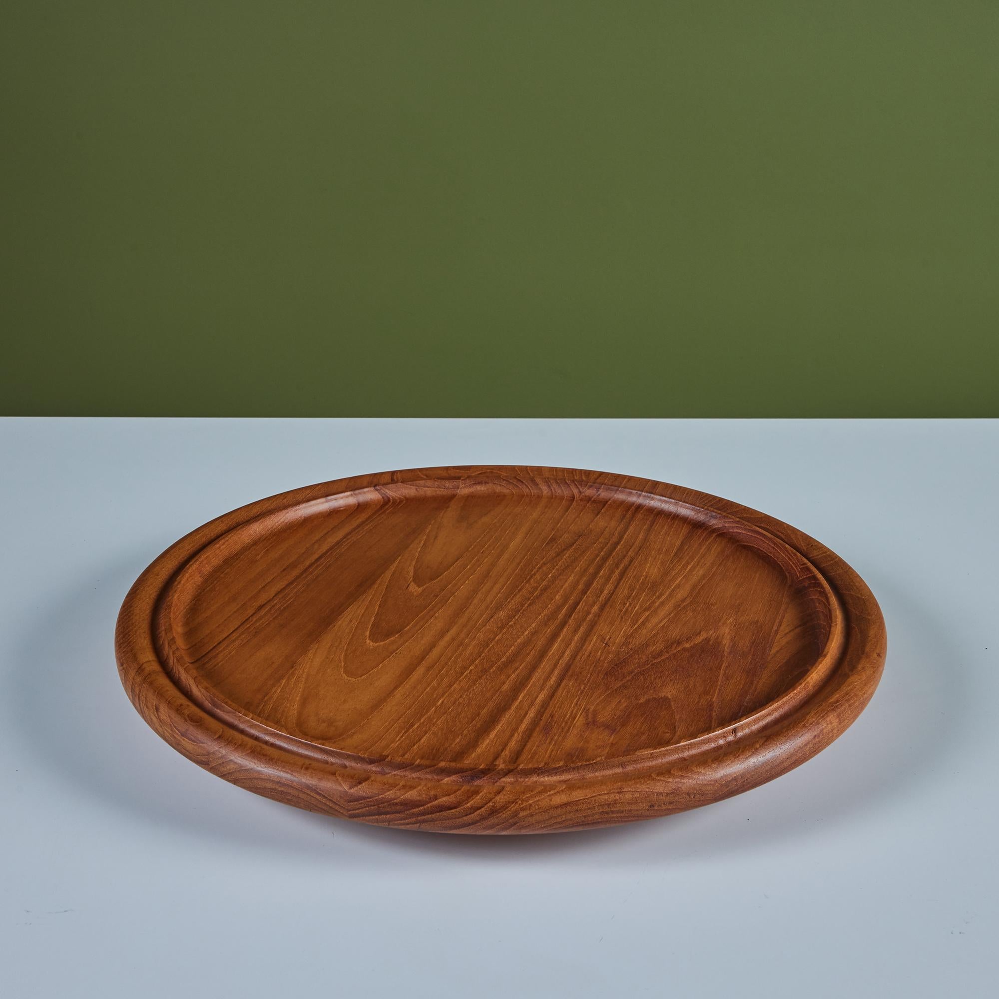Dansk is one of the most beloved and celebrated makers of Mid-Century table and kitchenware; whether its their use of teak or enamel, their designs endure even 60 years later, making their pieces highly sought after and collectible. This round tray