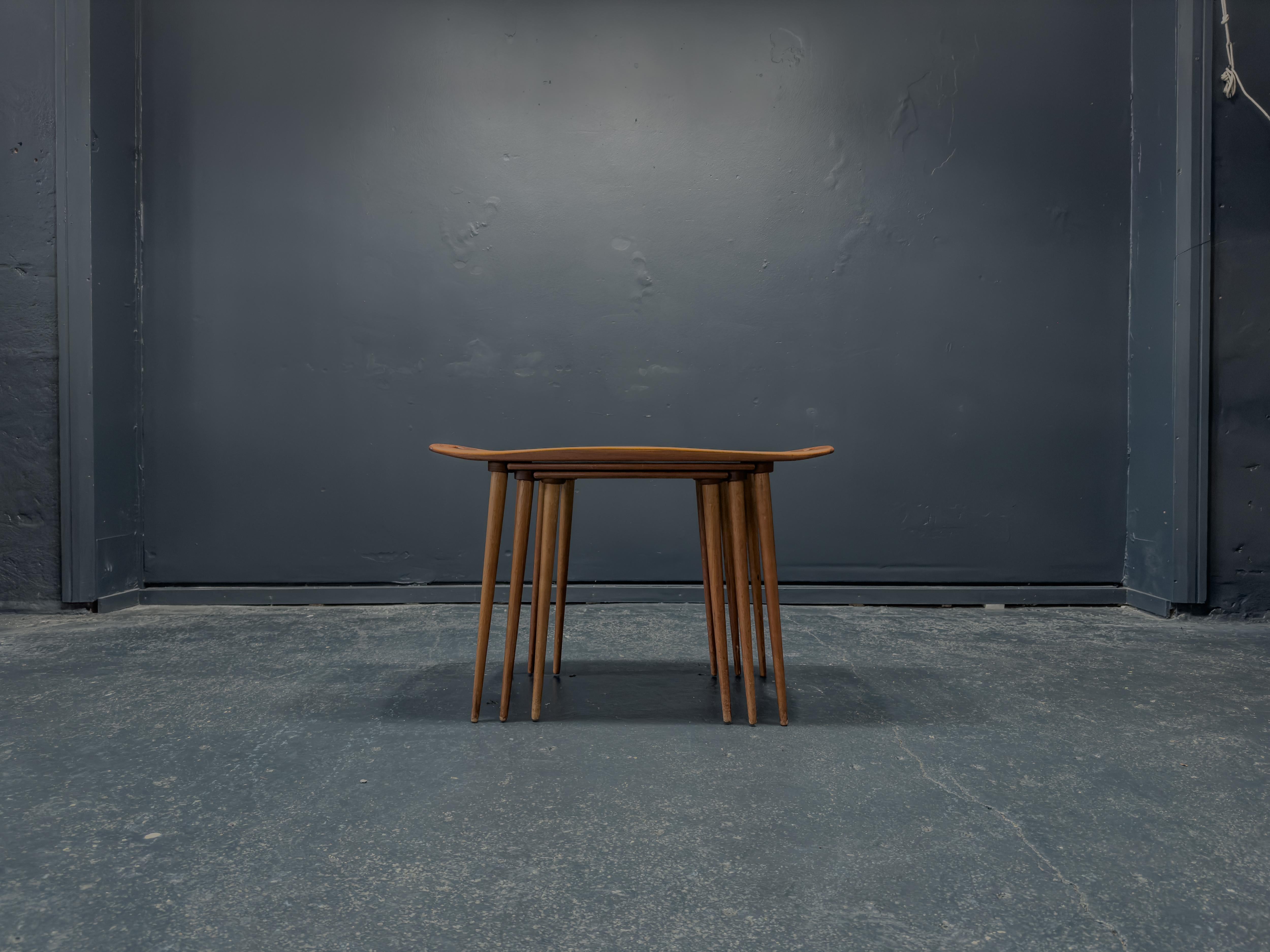 Prodotto da IHQ intorno al 1950, questo fantastico set di tre tavolini da salotto è stato creato dal designer danese Jens Quistgaard. Il più grande dei tre tavoli ha una forma unica, simile a un vassoio, con bordi ben rifiniti e maniglie ricurve.