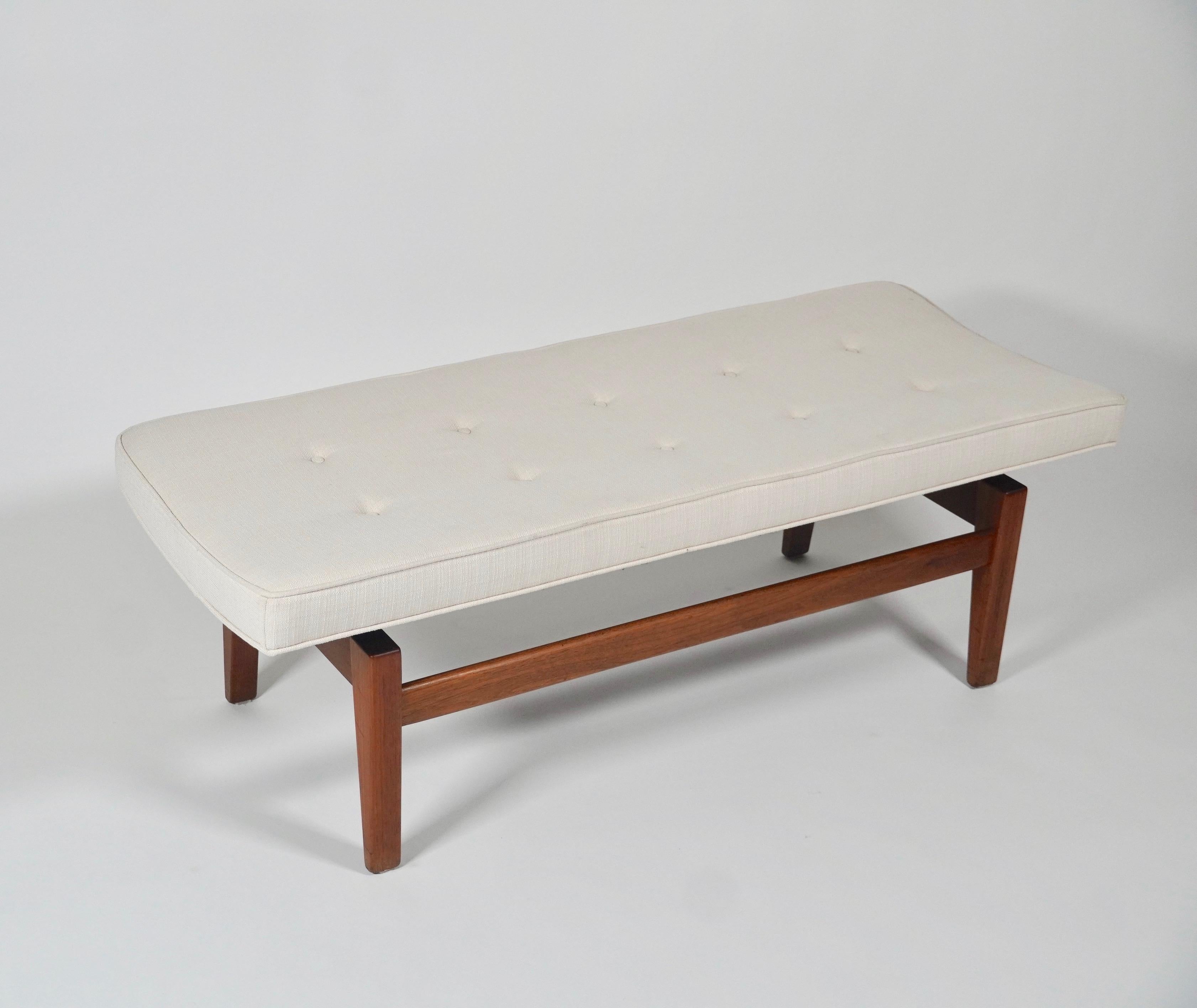 Floating bench with silk upholstery and walnut frame, designed by Danish American designer Jens Risom (1916-2016) for his company Jens Risom Design Inc. The bench is designed to create the effect of it floating, along with a slight curve along the