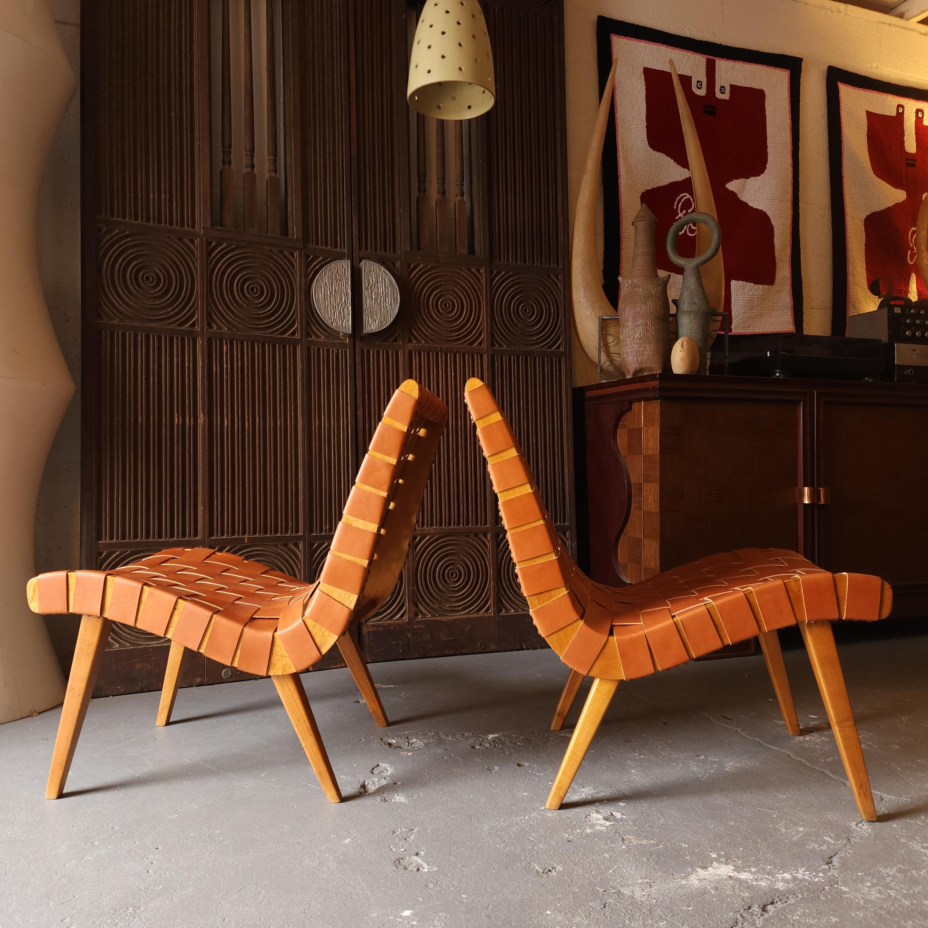 Incredible pair of Jeans Risom 654w chairs designed in 1941. Beautiful curves, sleek design, buttery leather, and patinated wood combine to create such a warm and exquisite feeling in these perfectly ergonomic classics. These have been restrapped