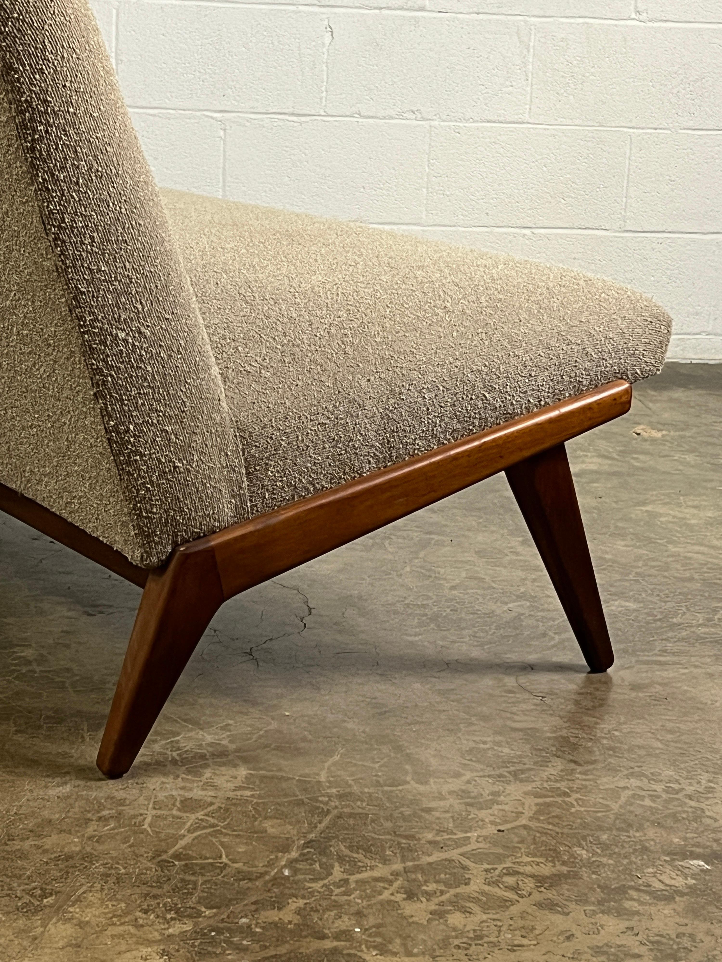 An early Jens Risom armless sofa with maple frame. Older restoration in Knoll boucle.