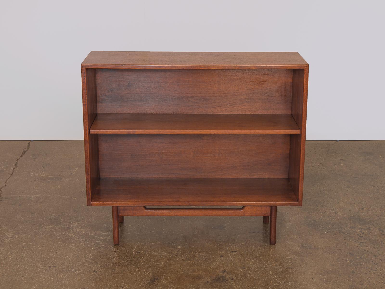 Gorgeous walnut bookcase by Danish American designer Jens Risom. Its sturdy, functional design is paired with a rich and vibrant wood grain. The bookcase is in excellent condition featuring an elegant patina, height adjustable shelf and the