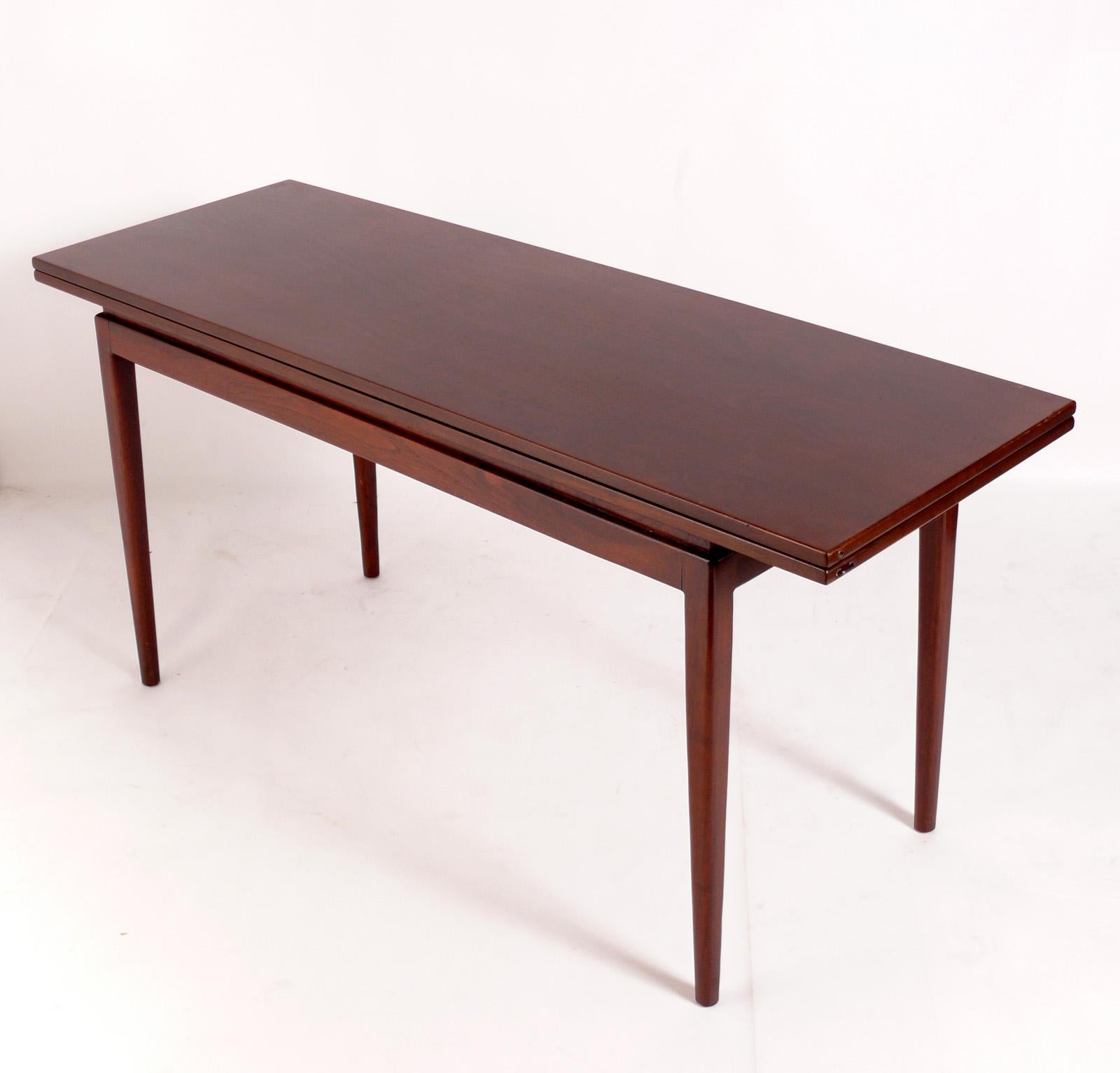 Clean Lined Mid Century Walnut Console Table, designed by Jens Risom, American, circa 1950s. This table is the perfect multi use table for an NYC apartment. It can be used as a console table, desk, or bar, and then the table top flips open to dining