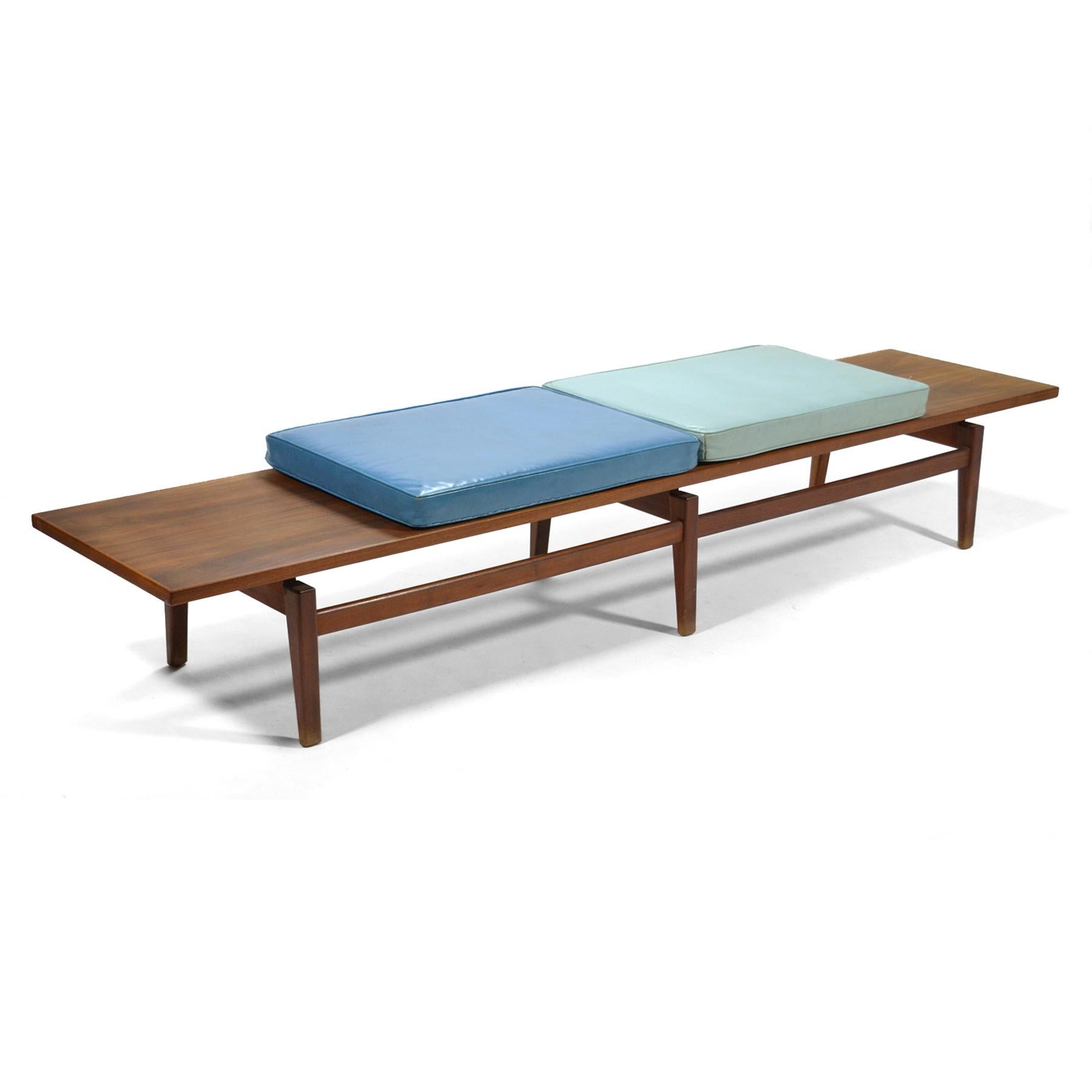 This spectacular eight foot long table or bench by Jens Risom is not only a beautiful design with it's architectural base with tapered legs and a top that appears to float, it is highly functional with it's blue leather upholstered cushions. 

The