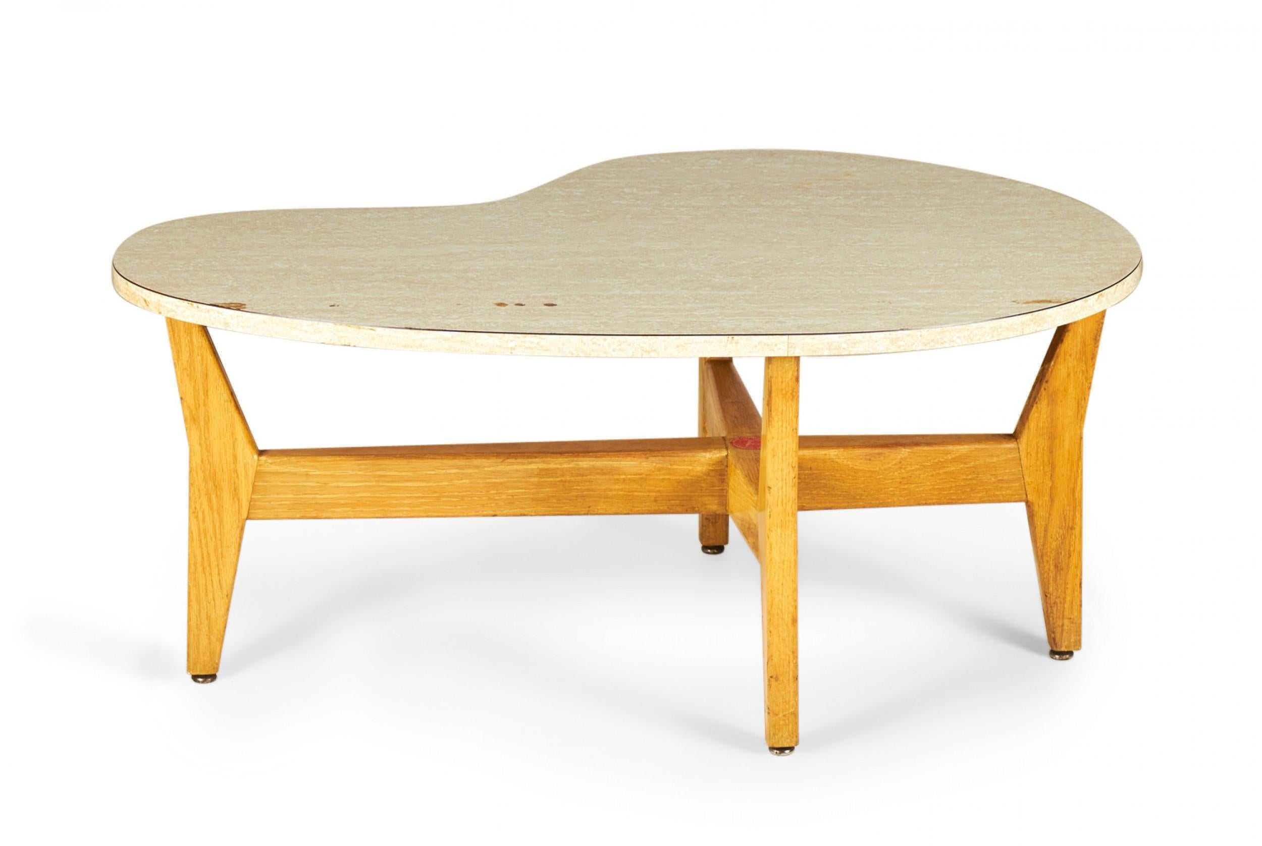 Danish Mid-Century coffee / cocktail table with a kidney-shaped table top with a beige marbled mica veneer resting on a walnut base with a cruciform stretcher and angled legs. (JENS RISOM)
