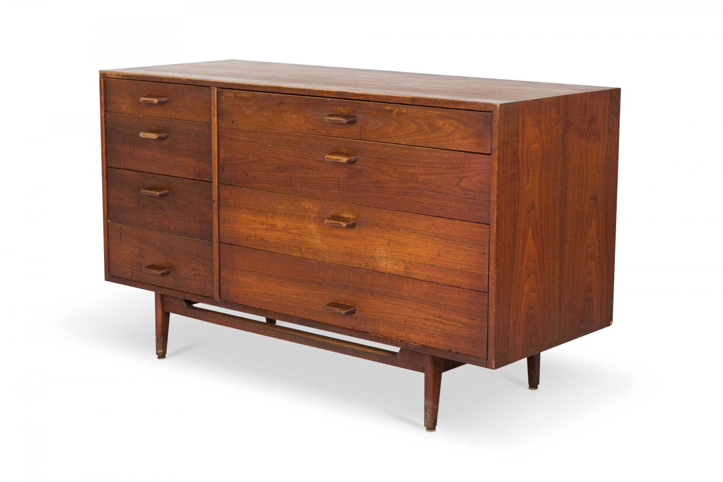 Danish Mid-Century walnut 8-drawer dresser with four narrow drawers on the left and four wider drawers on the right, the top of which folds down to create a writing desk, all with rounded rectangular wooden drawer pulls in a walnut cabinet, resting