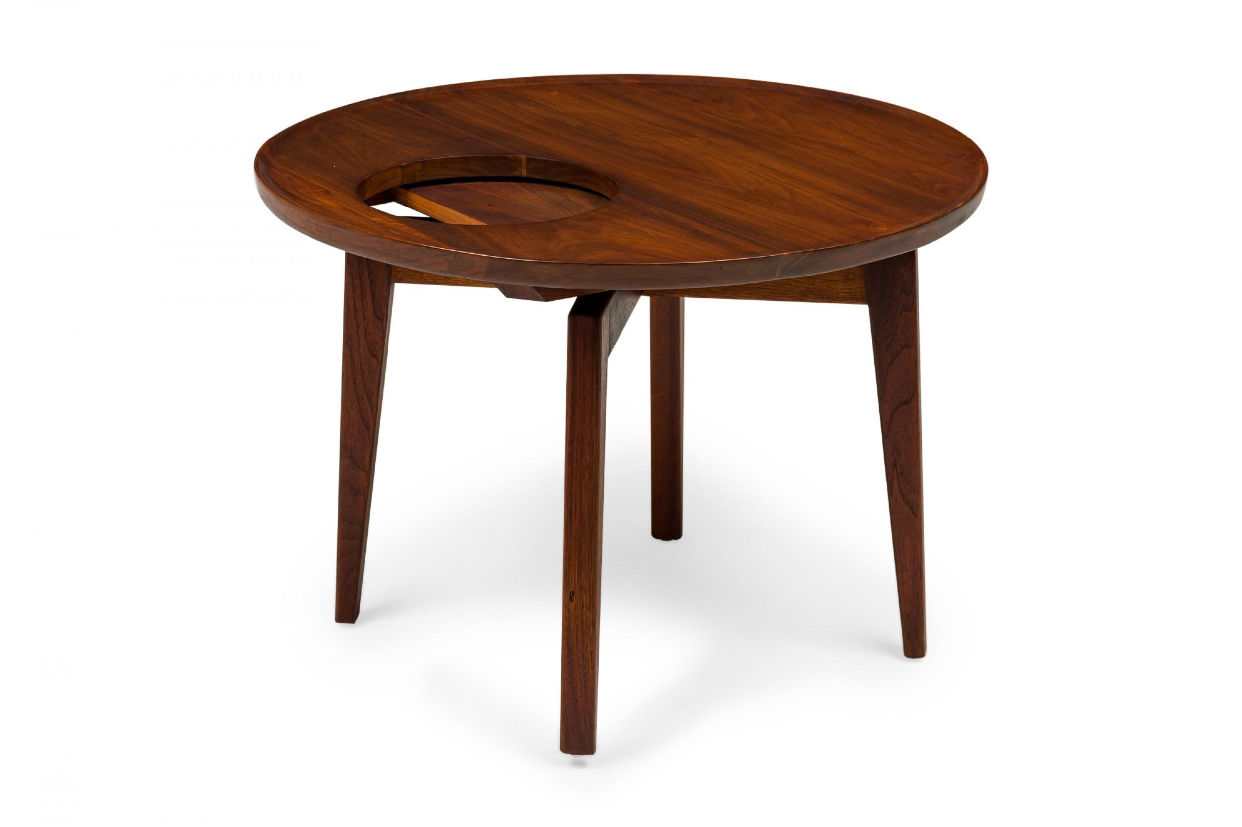 Danish Mid-Century lazy susan end / side table with a rotating circular top with an off-center circular cutout supported by four tapered square wooden legs. (JENS RISOM)
