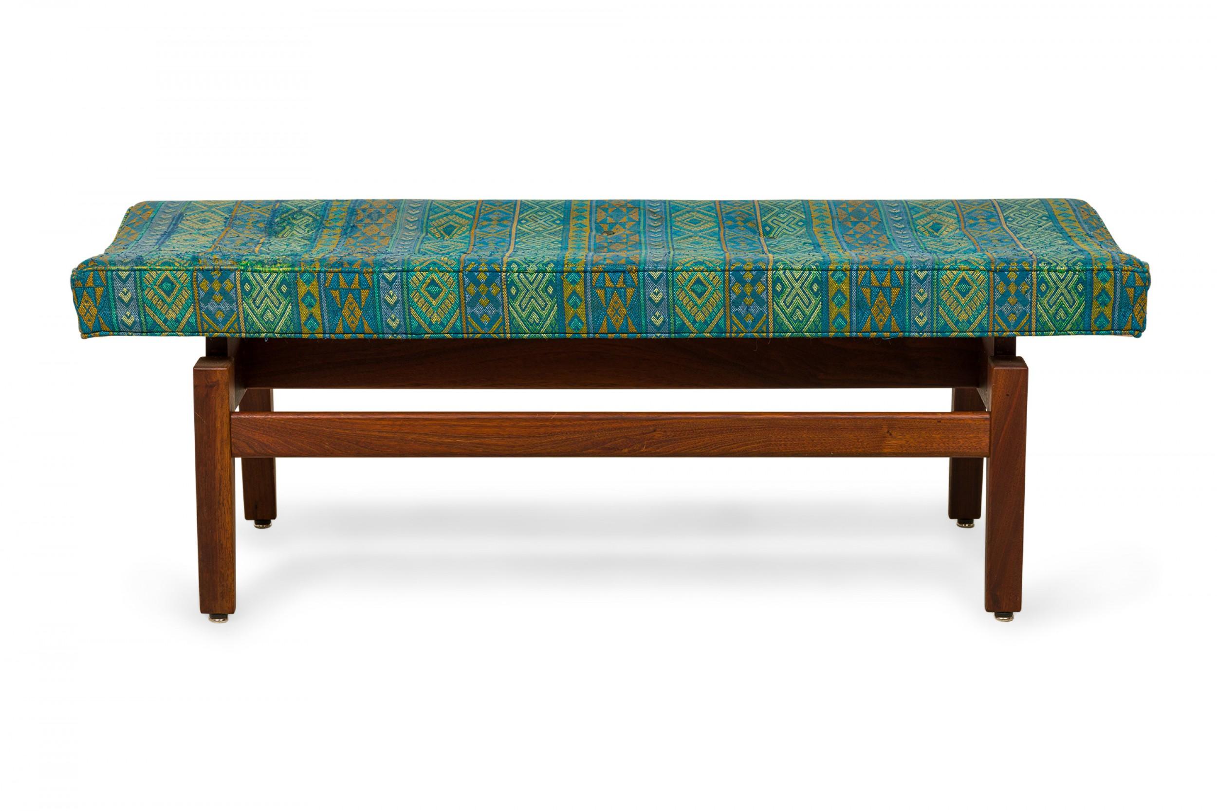 Danish mid-century rectangular floating bench with a banded Southwestern blue and green patterned fabric upholstered seat resting on a wooden floating frame base. (JENS RISOM).
   
