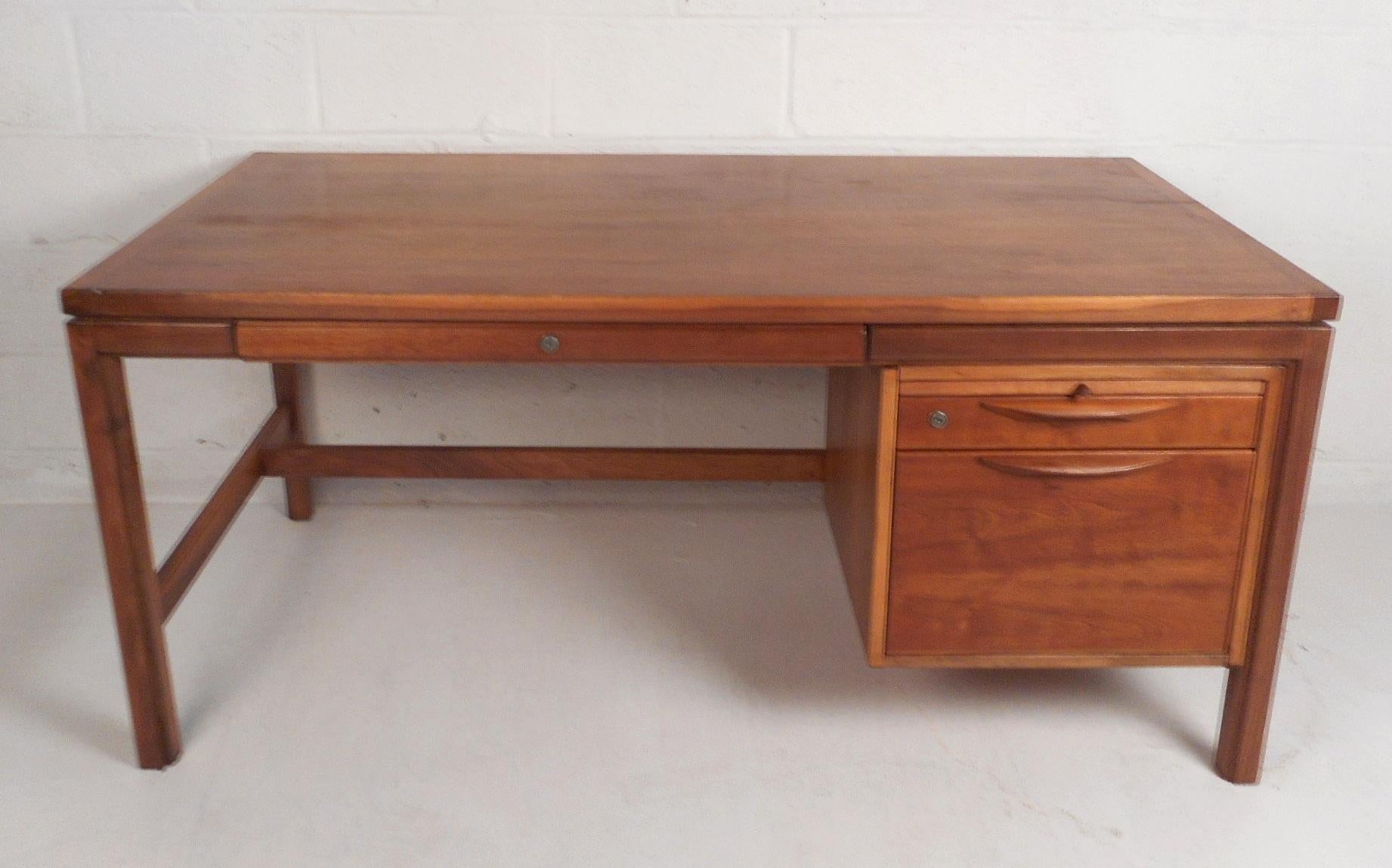 This beautiful Mid-Century Modern desk features three drawers and a pull-out table. A stylish design with plenty of room for storage and plenty of work space. Quality construction with sculpted drawer pulls and a finished back. This newly refinished