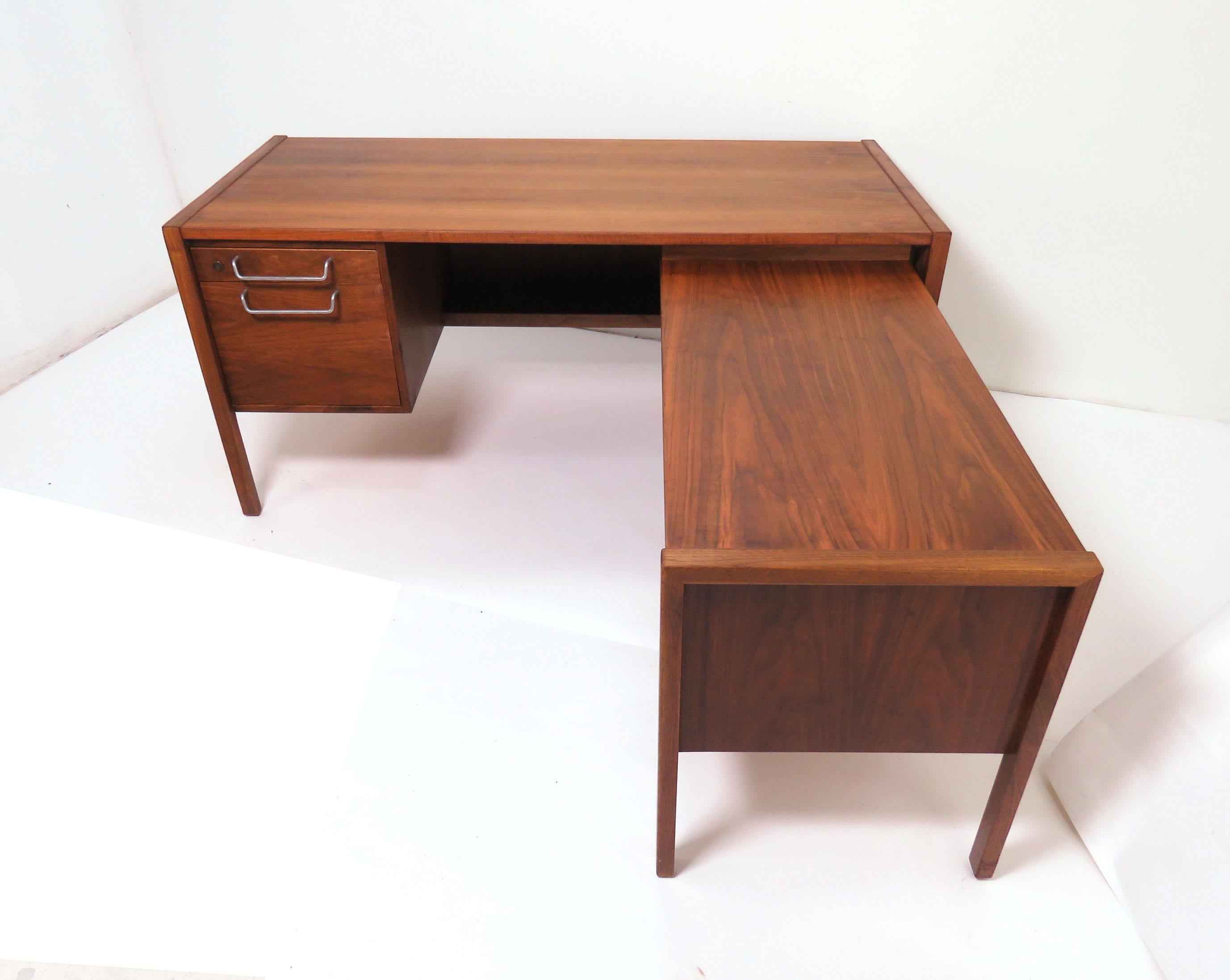 Large Mid-Century Modern executive desk in walnut by Jens Risom, circa 1960s, bank of drawers on the left include a pencil organizer and a deep drawer for hanging files. Desk includes an optional (removable) return with under shelf that mounts to