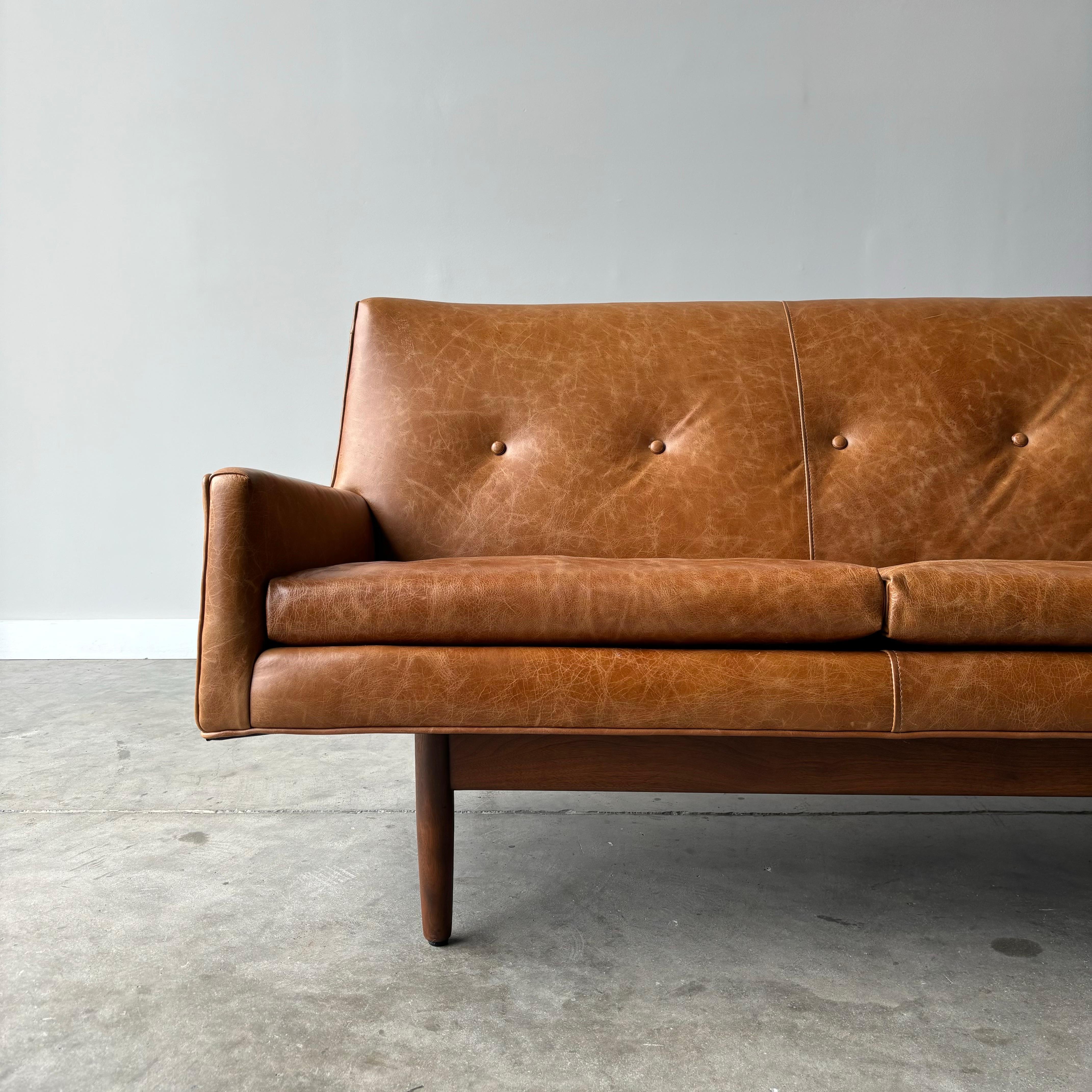 Danish modern design at its finest.  New leather to this floating sofa by Jens Risom.  Dating to the 1960s with beautiful sculpted lines and walnut base.

70