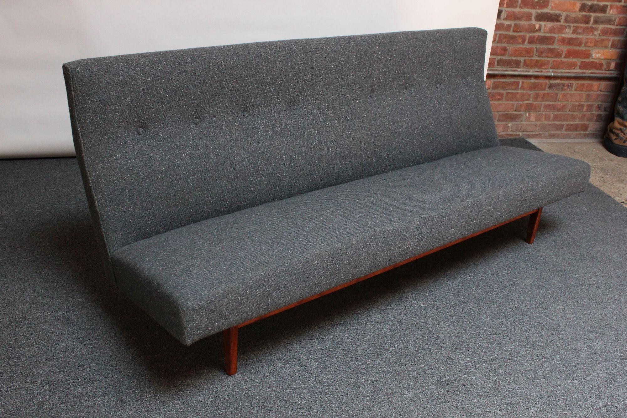 Dreisitziges Sofa, Modell #U250, entworfen von Jens Risom für Risom Design in den 1950er Jahren. Er besteht aus einem skulpturalen Sockel aus Nussbaumholz, auf dem der getuftete Sitz mit hoher Rückenlehne montiert ist. Scharfe, modernistische