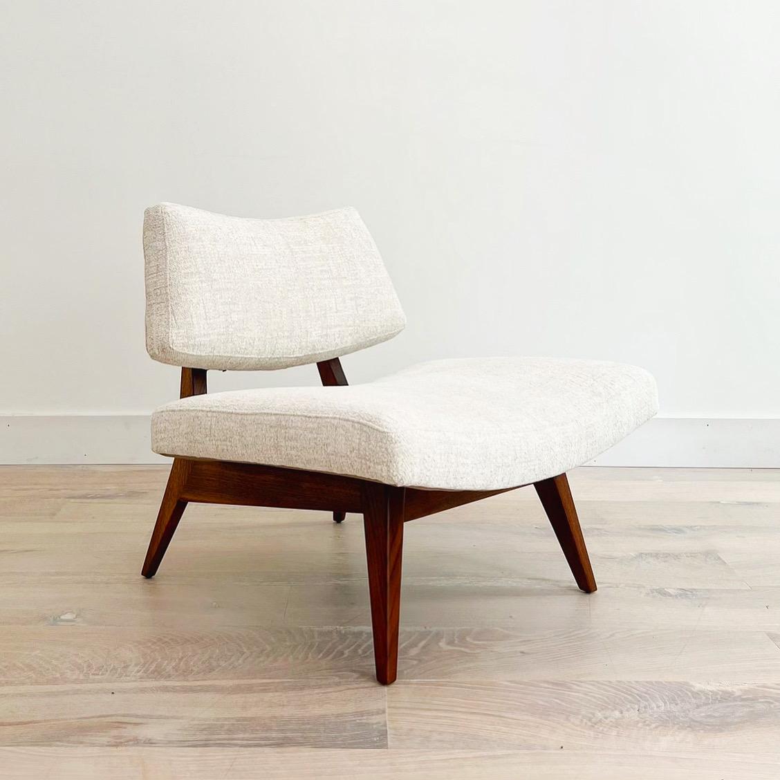 Early Jens Risom low lounge chair in solid American black walnut and a creamy white boucle. Oversized and stout with clean modern lines, a generously deep seat and a curved back. Subtle, yet striking - this chair commands a space while providing the