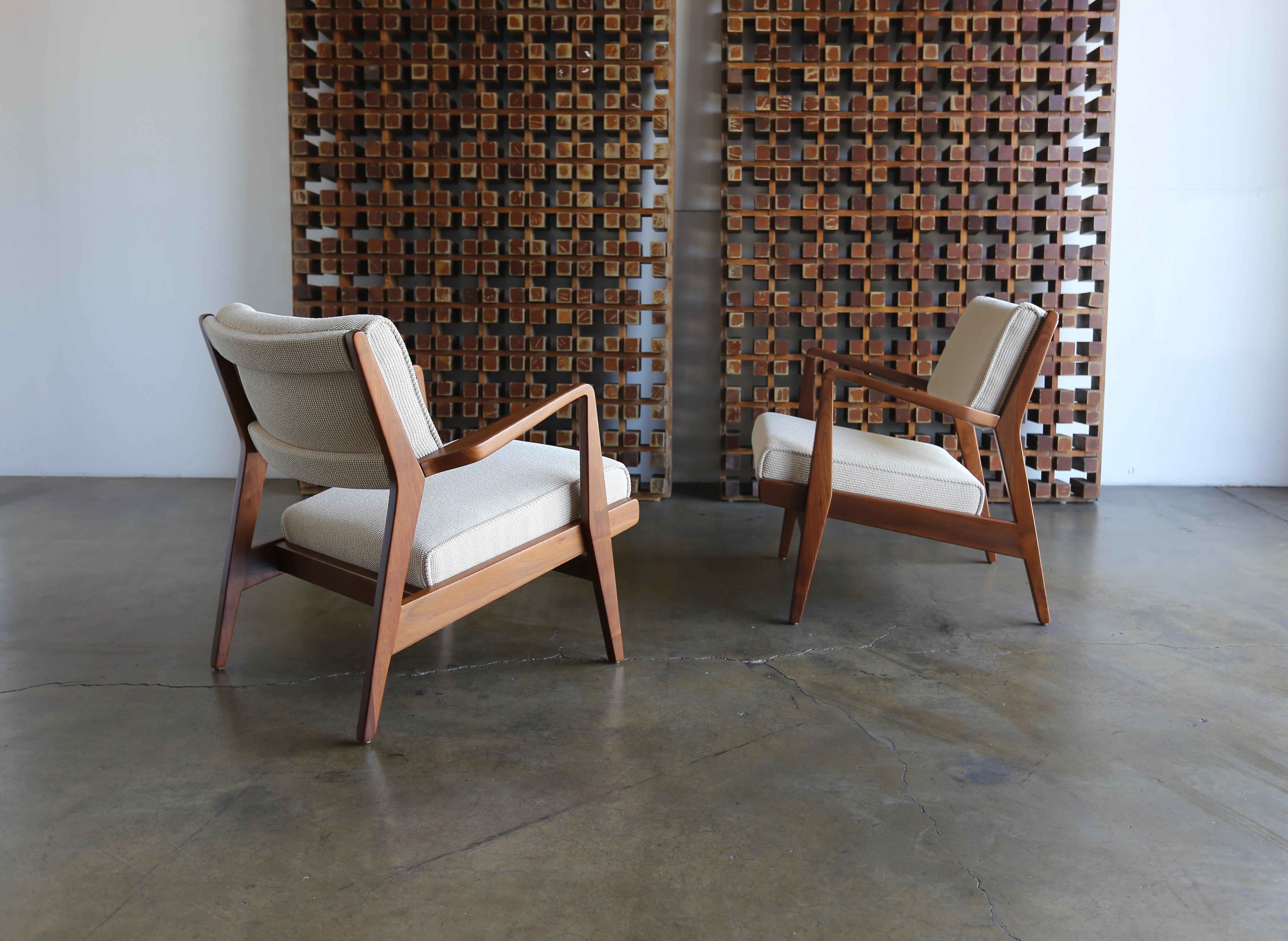 Pair of walnut framed lounge chairs by Jens Risom for Jens Risom Designs. This pair has been professionally restored.