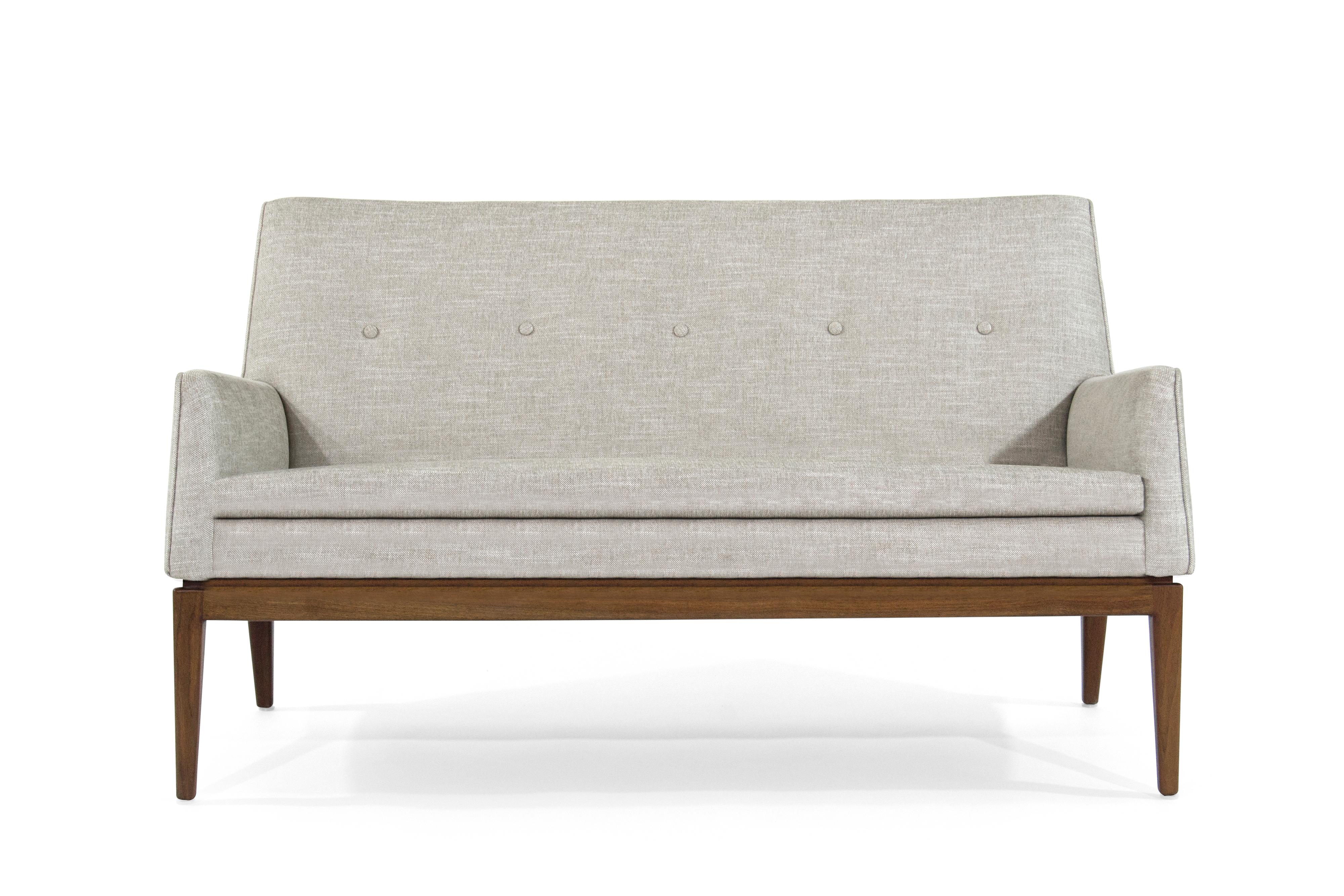 Fully restored loveseat designed by Jens Risom, circa 1950s. Newly upholstered in taupe linen, walnut base fully restored.