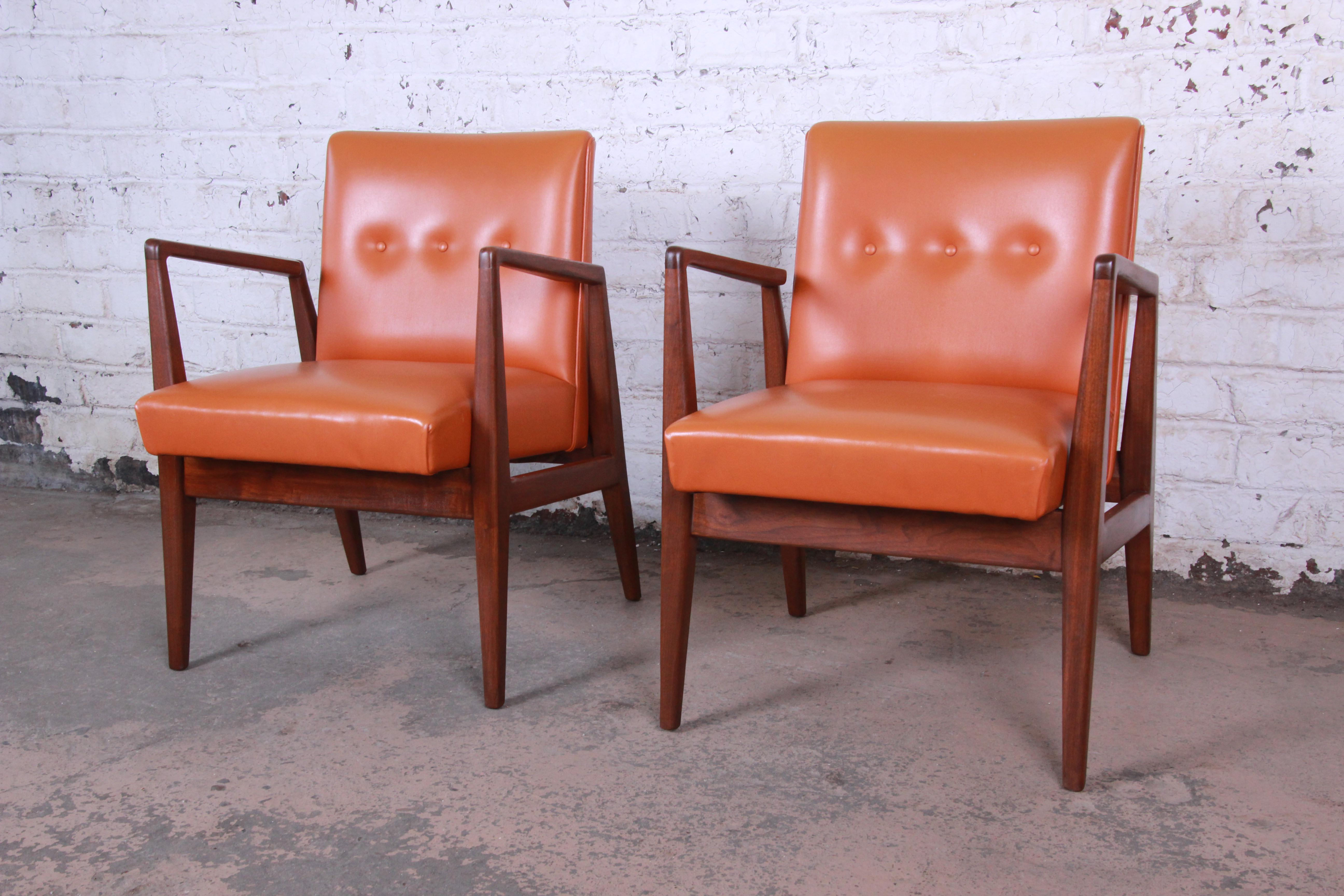 Offering an exceptional pair of Mid-Century Modern sculpted walnut lounge or club chairs designed by Jens Risom. The chairs feature gorgeous solid sculpted walnut frames and original tufted orange vinyl upholstery. The frames have been expertly