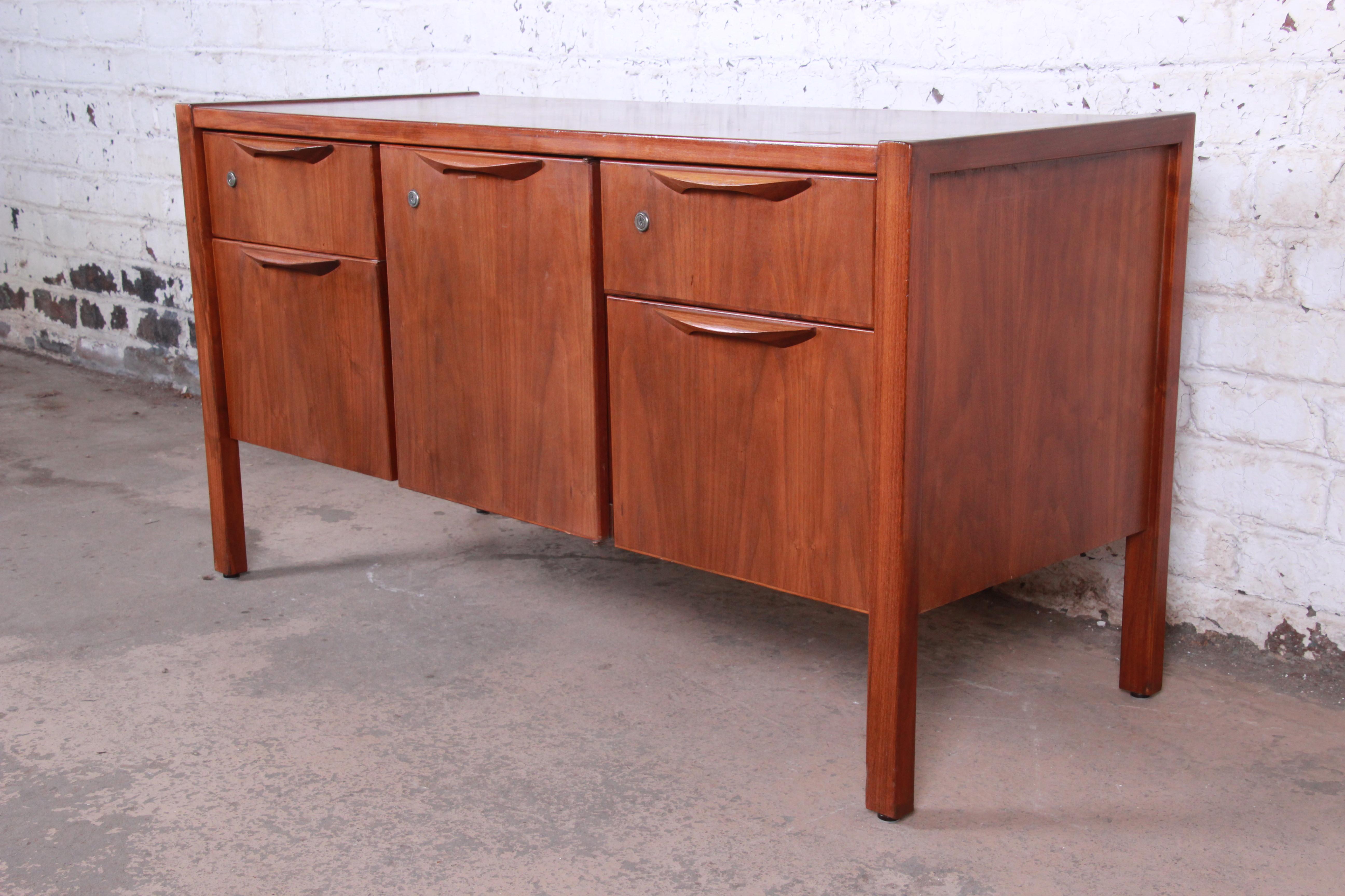 Mid-Century Modern walnut credenza. Procured from the Avon Headquarters in New York City.

Designed by Jens Risom for Jens Risom Design, Inc.

USA, 1960s

Walnut and sculpted walnut drawer pulls. Finished on all sides.

Measures: 54.63