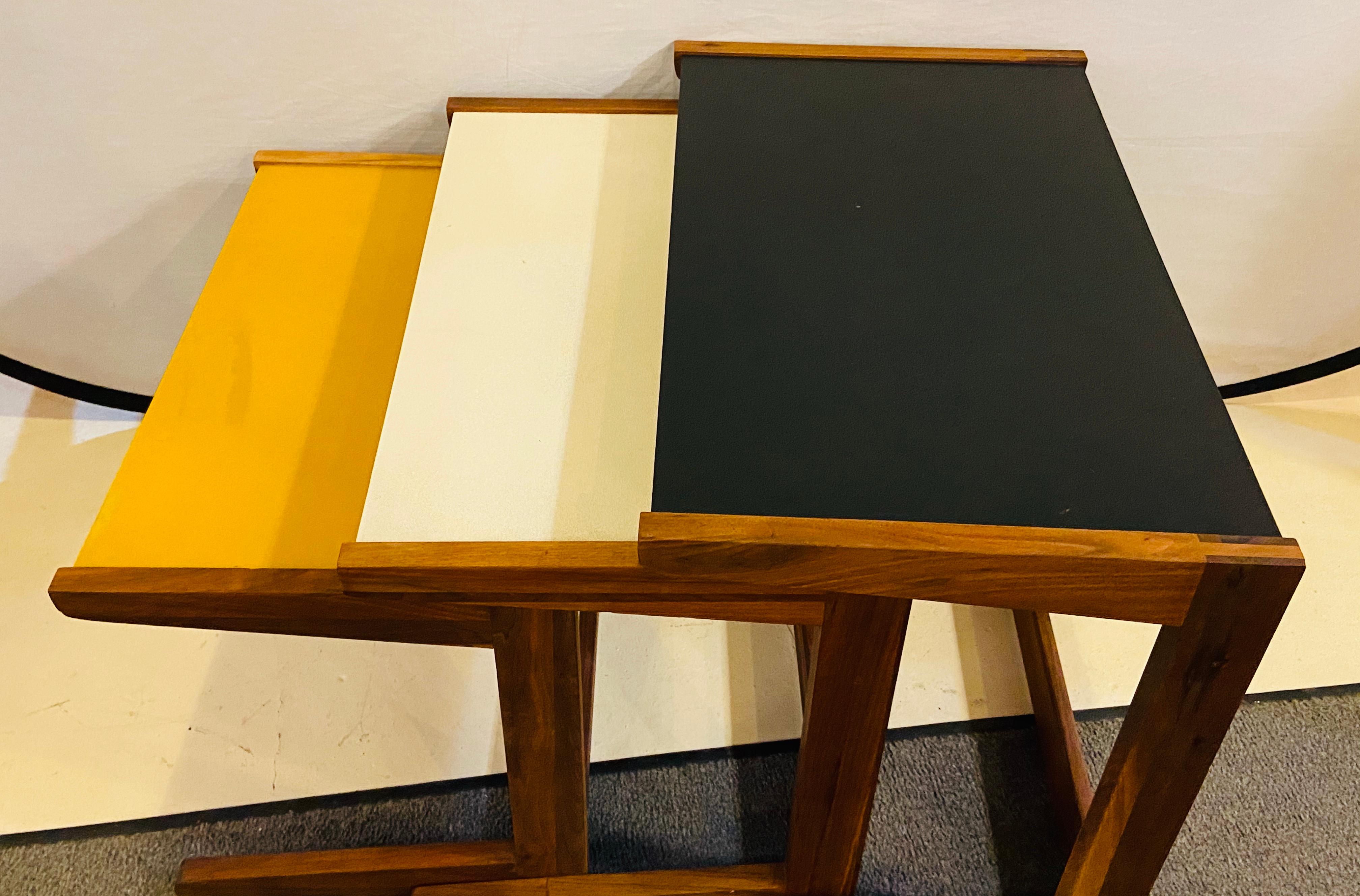 A set of three Mid-Century Modern walnut vinyl nesting side tables by Jens Risom. The stylish nesting tables are made of walnut and vinyl in while, yellow and black. A beautiful addition to your living room or any living area.

Size: Large 26.37