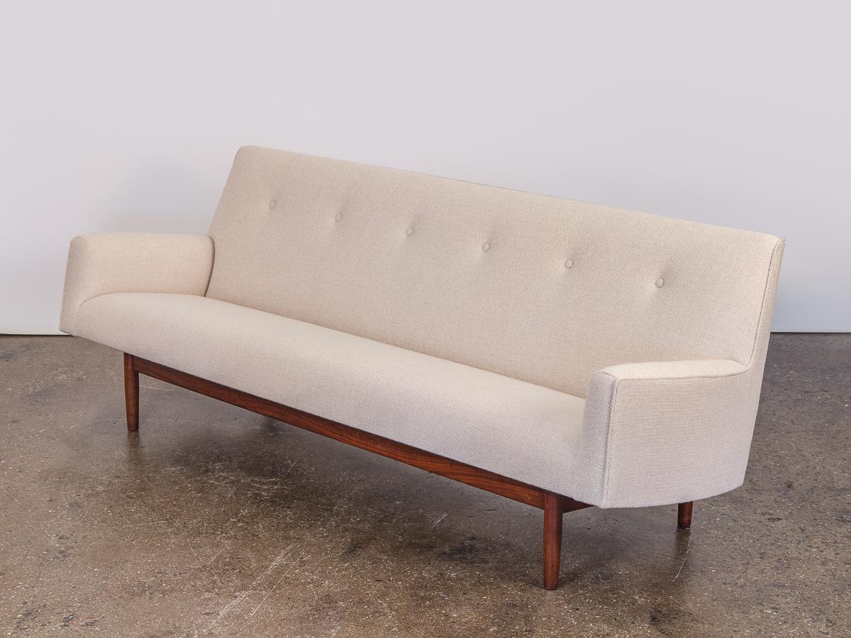 Stunning 1960s walnut frame upholstered sofa attributed to Jens Risom. A minimal, elegant Silhouette with clean lines. No expense was spared in the restoration of this sofa. Newly upholstered in a creamy ivory Maharam wool it is textural and soft to