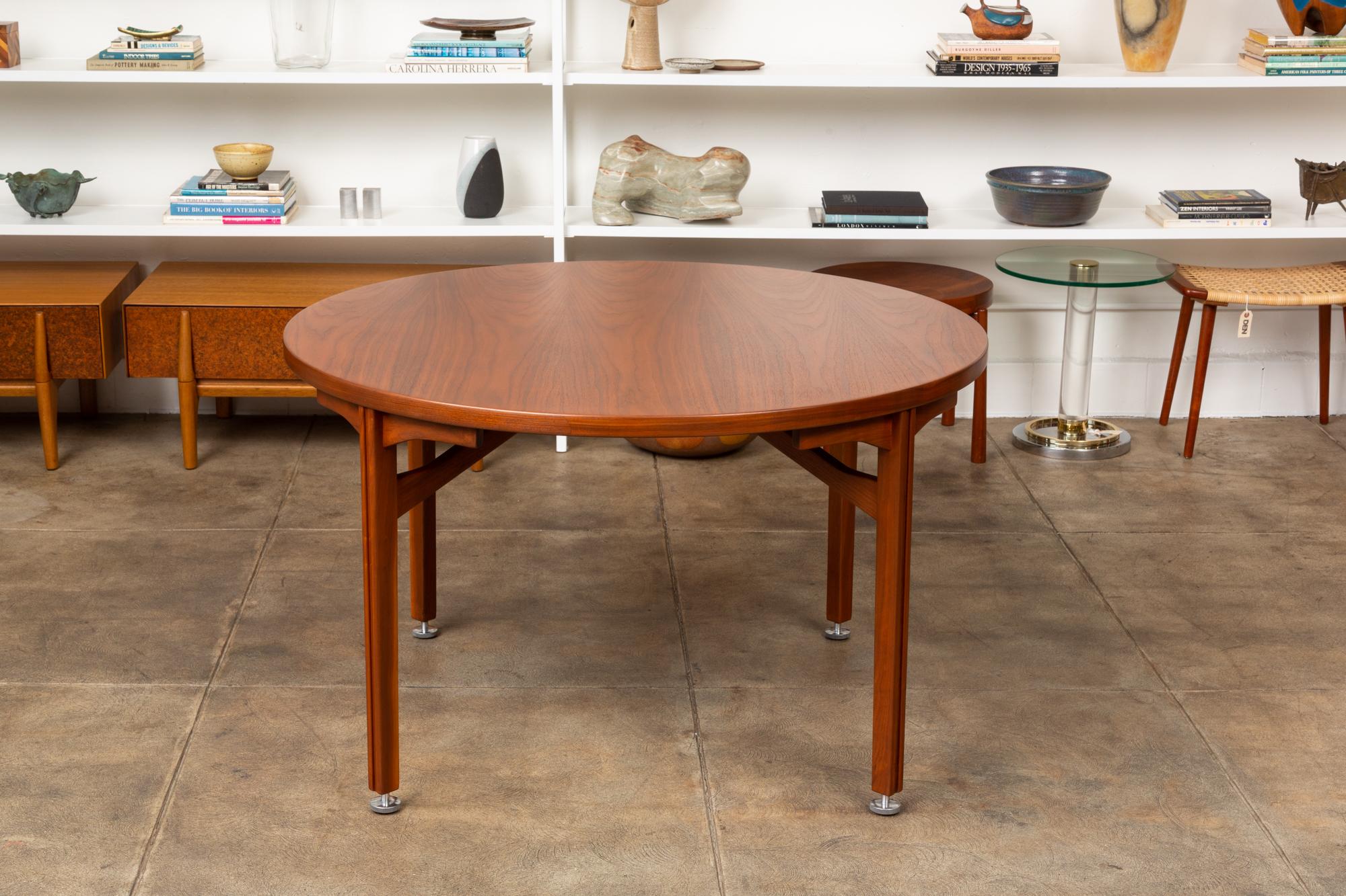Round walnut dining table by Jens Risom for Risom Design, USA, circa 1960s. The table features a round walnut top supported by walnut legs with adjustable aluminum levelers. Retains original Risom Design Inc. tag on underside.

Condition;