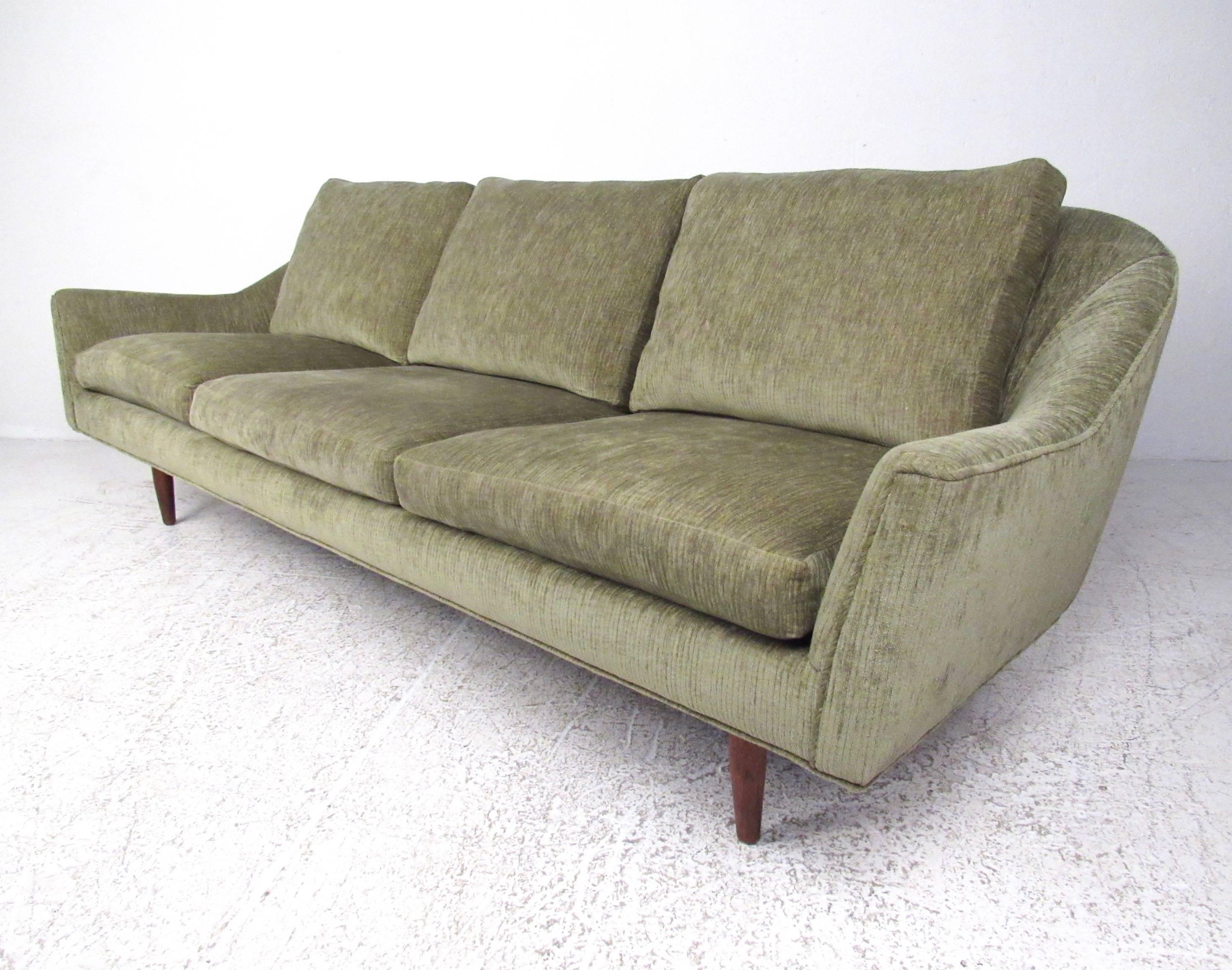 This stylish three-seat sofa features the Mid-Century Modern design of Jens Risom while featuring updated upholstery. Sturdy teak base adds to the Scandinavian Modern appeal of this spacious and comfortable sofa. Please confirm item location (NY or