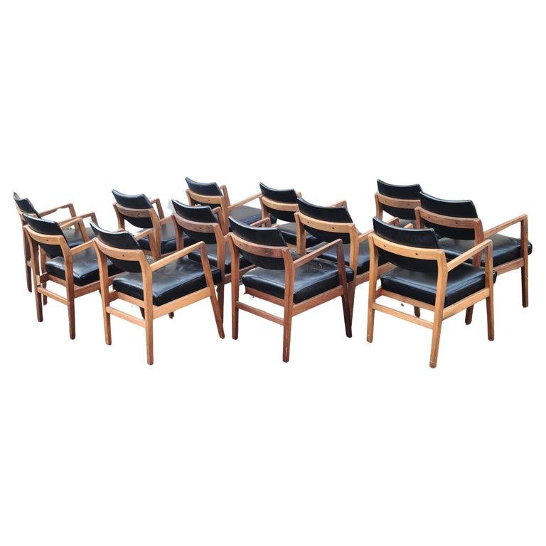 Set of 12 Arm Chairs by Jens Risom.
Walnut Frames. 
11 have Vintage Leather seat and backrest.
3 of the seats are distressed.
1 has vintage leather backrest and vinyl seat.


