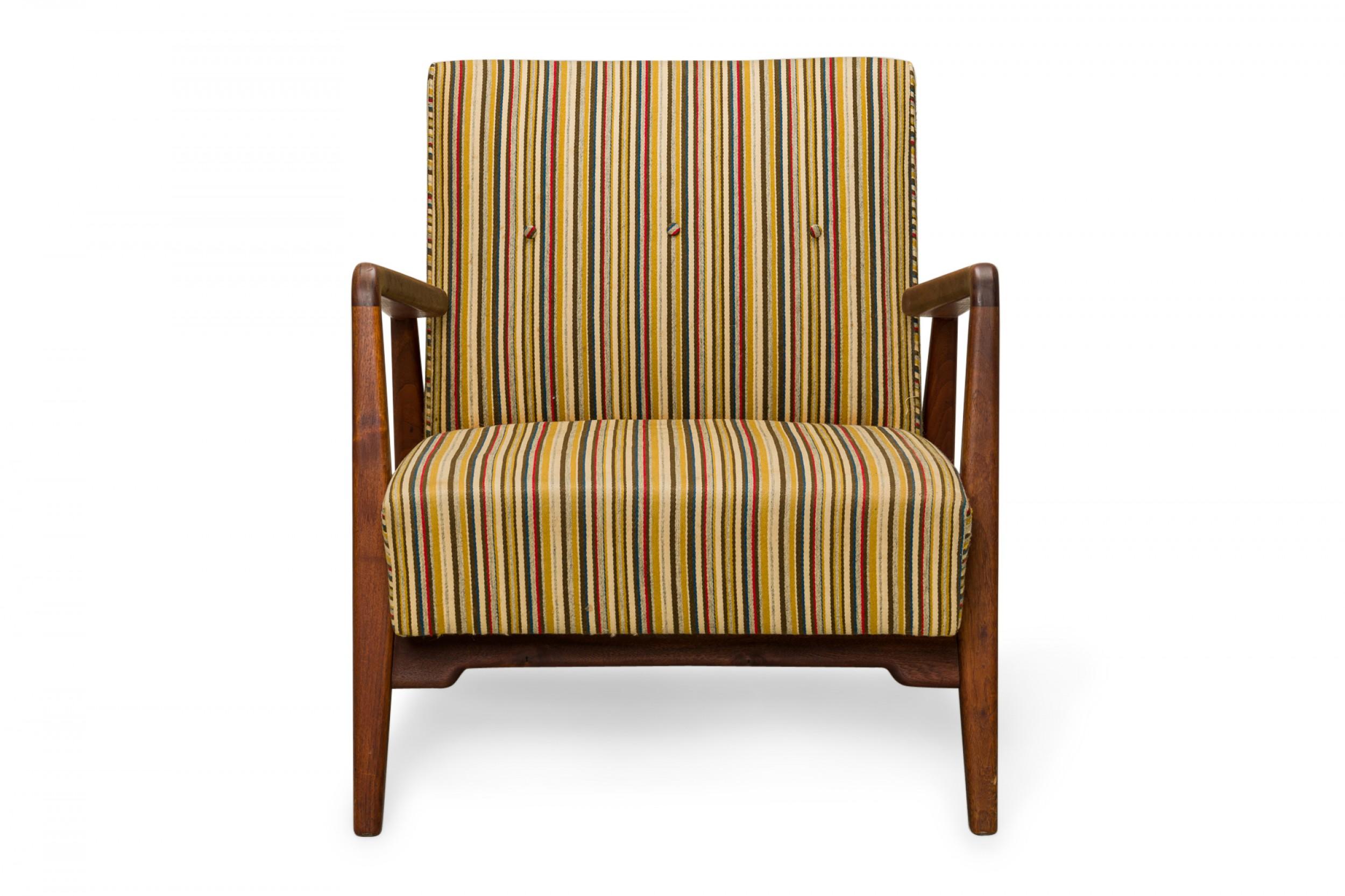 Danish mid-century lounge armchair with a shaped teak frame with two wooden armrests, and seat and back cushions upholstered in a blue, gold, red, and beige striped fabric, resting on four rounded tapered legs. (JENS RISOM)
 