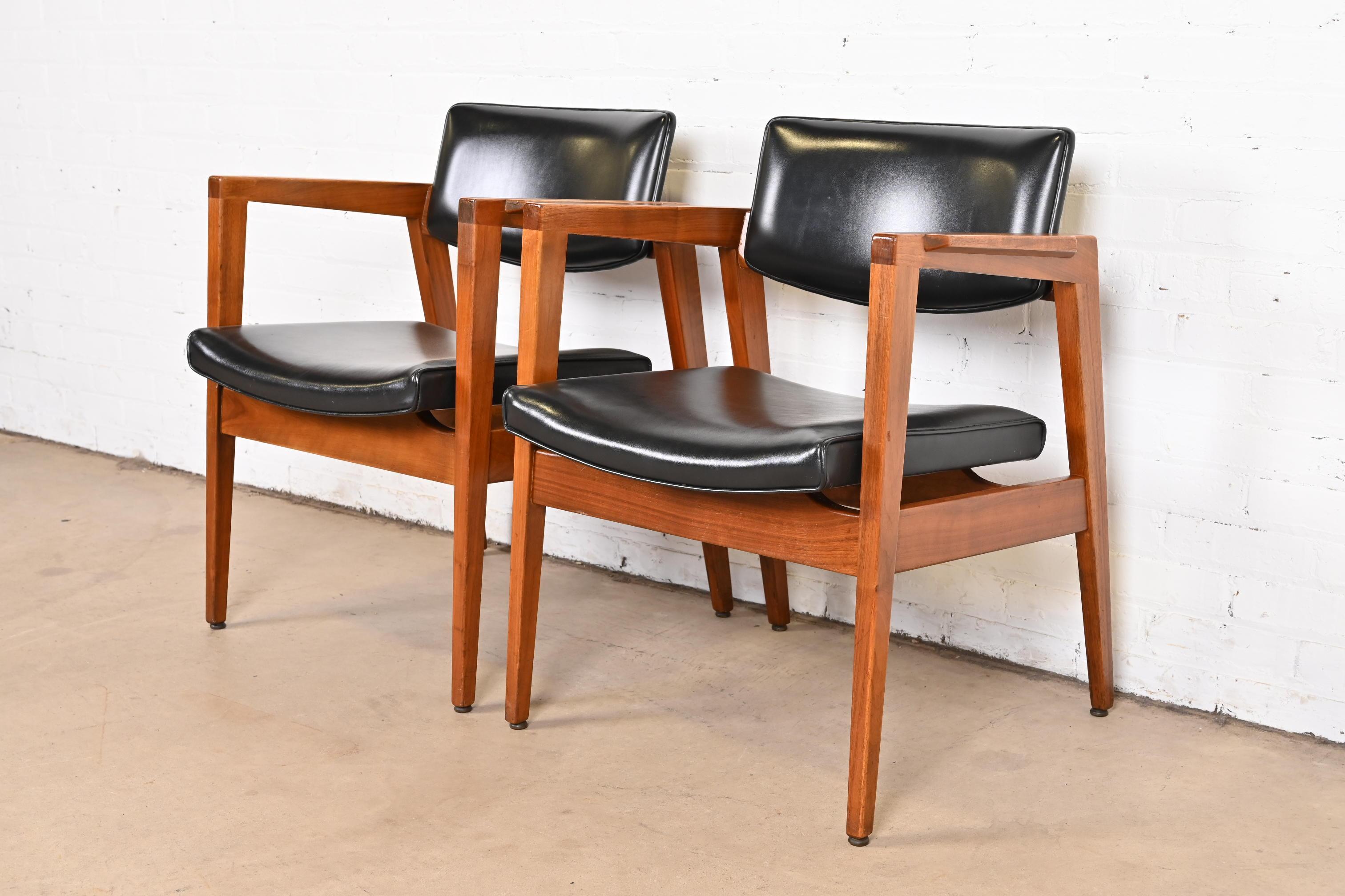 A sleek and stylish pair of Mid-Century Modern club chairs or lounge chairs

In the manner of Jens Risom

By Gunlocke

USA, 1960s

Gorgeous sculpted solid walnut frames, with original black vinyl upholstery.

Measures: 23.63