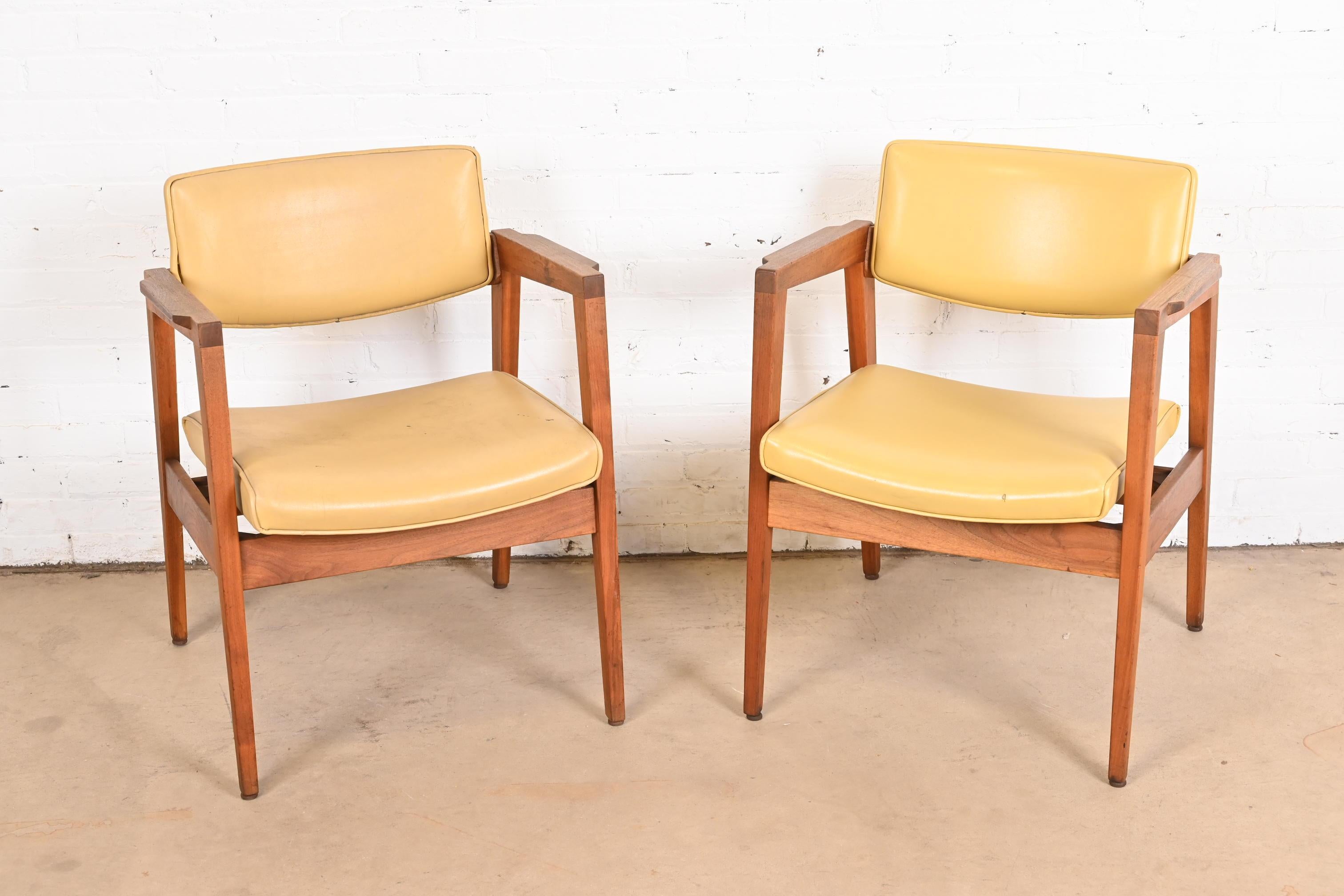 A sleek and stylish pair of Mid-Century Modern club chairs or lounge chairs

In the manner of Jens Risom

By Gunlocke

USA, 1960s

Sculpted solid walnut frames, with original yellow vinyl upholstery.

Measures: 23.75