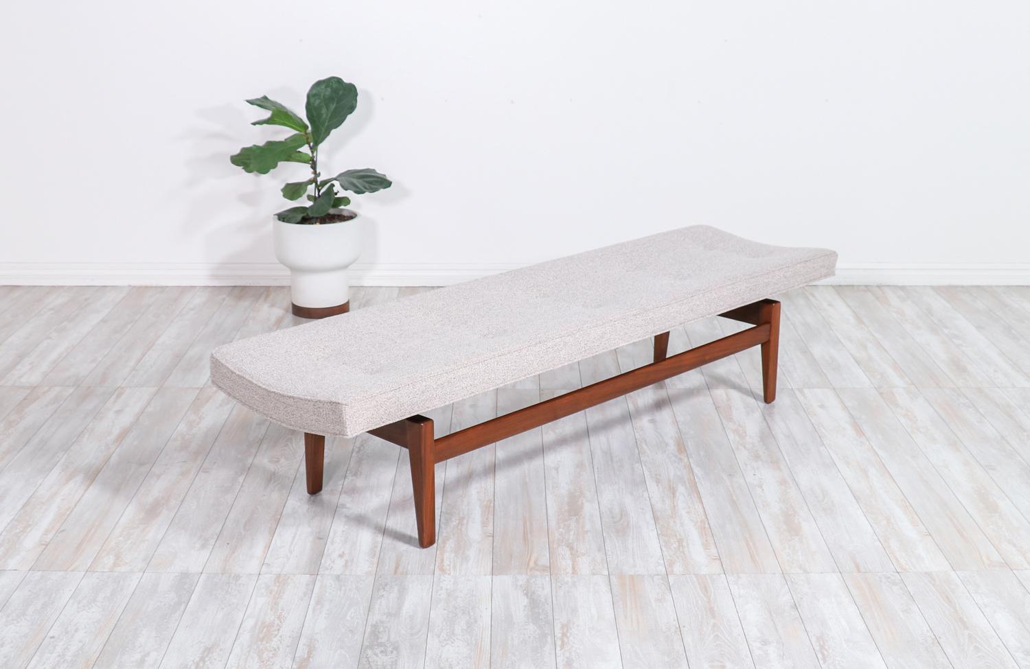 Jens Risom tufted bench with floating walnut base.