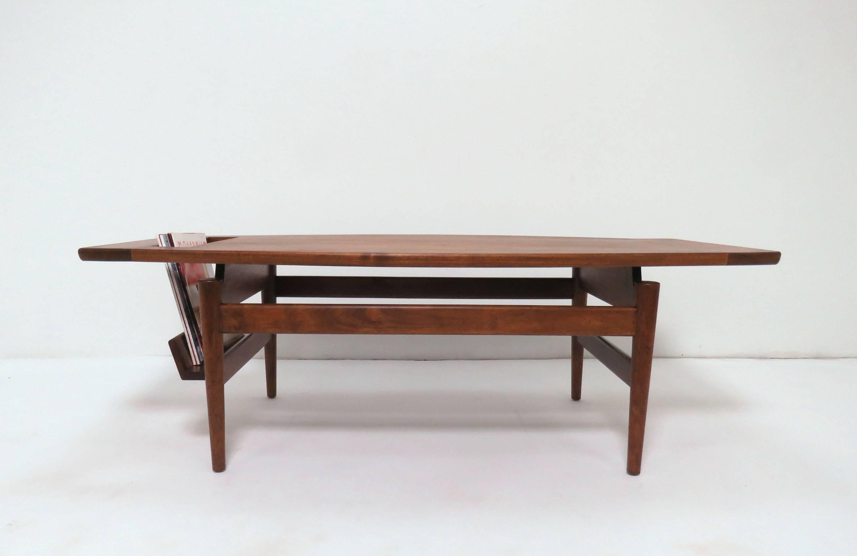 Coffee table in solid walnut by Jens Risom, model T390, with built-in magazine holder, circa 1950s.
