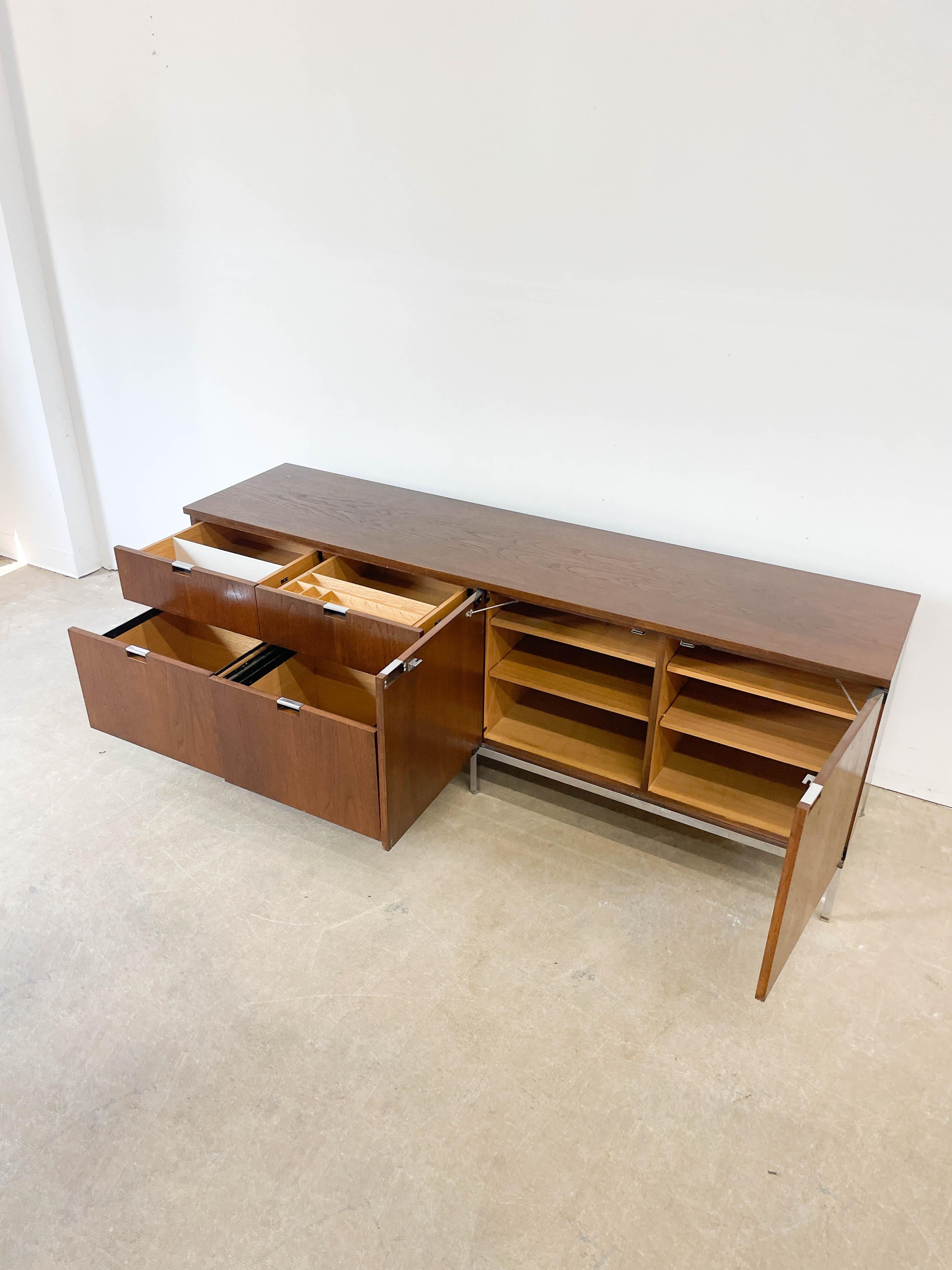 Functional and understated walnut credenza designed by Jens Risom for his own company, Jens Risom Design in the 1950s. This pieces features five drawers, two of which are hanging file drawers, a slide out typewriter tray and a larger storage