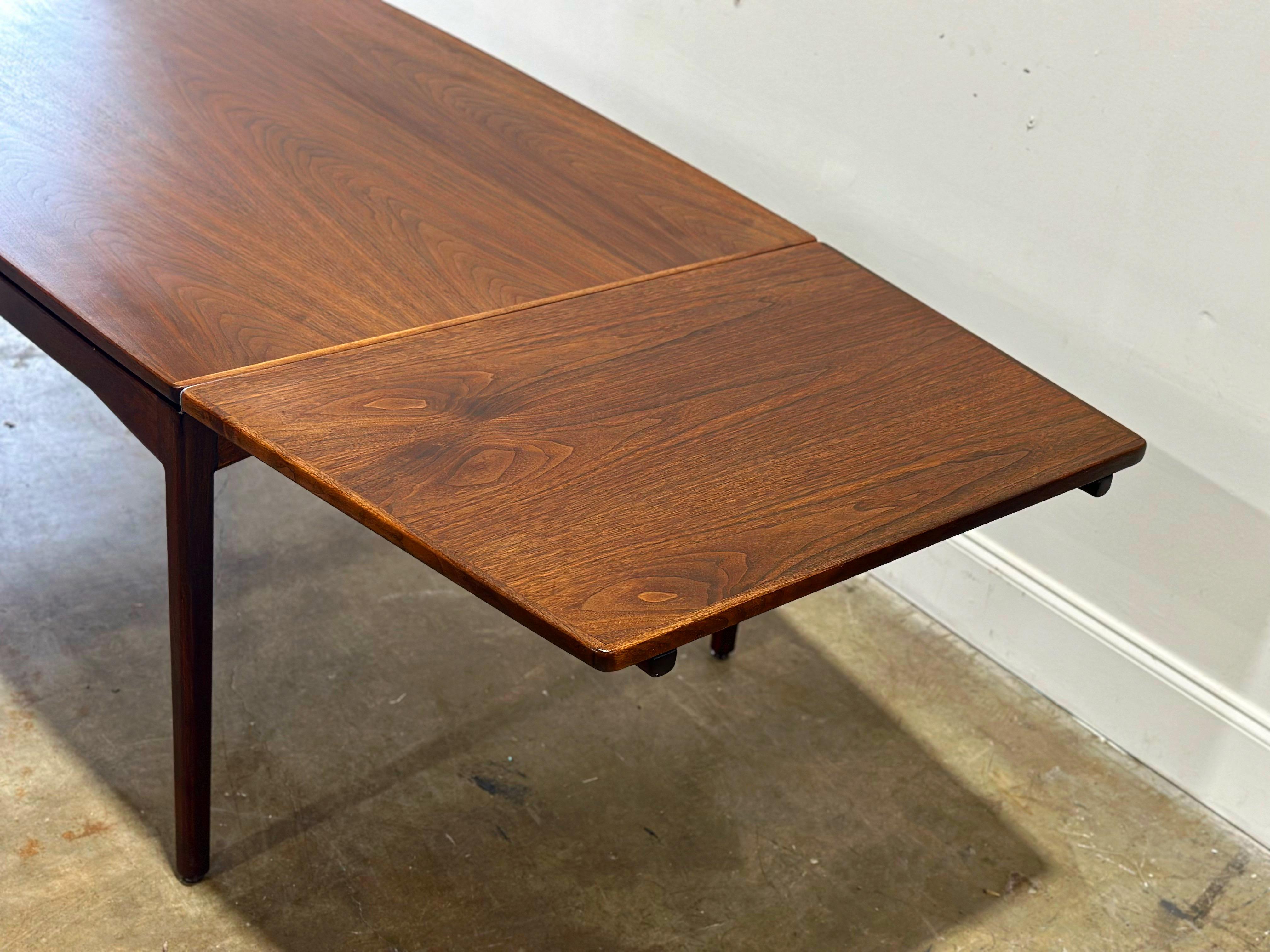 Stunning and rare large scale Mid-Century Modern dining table designed by Jens Risom for Jens Risom Design Inc. The table has two draw leaf leaves, which pullout from the narrow ends of the top, and store by tucking them under the top surface.