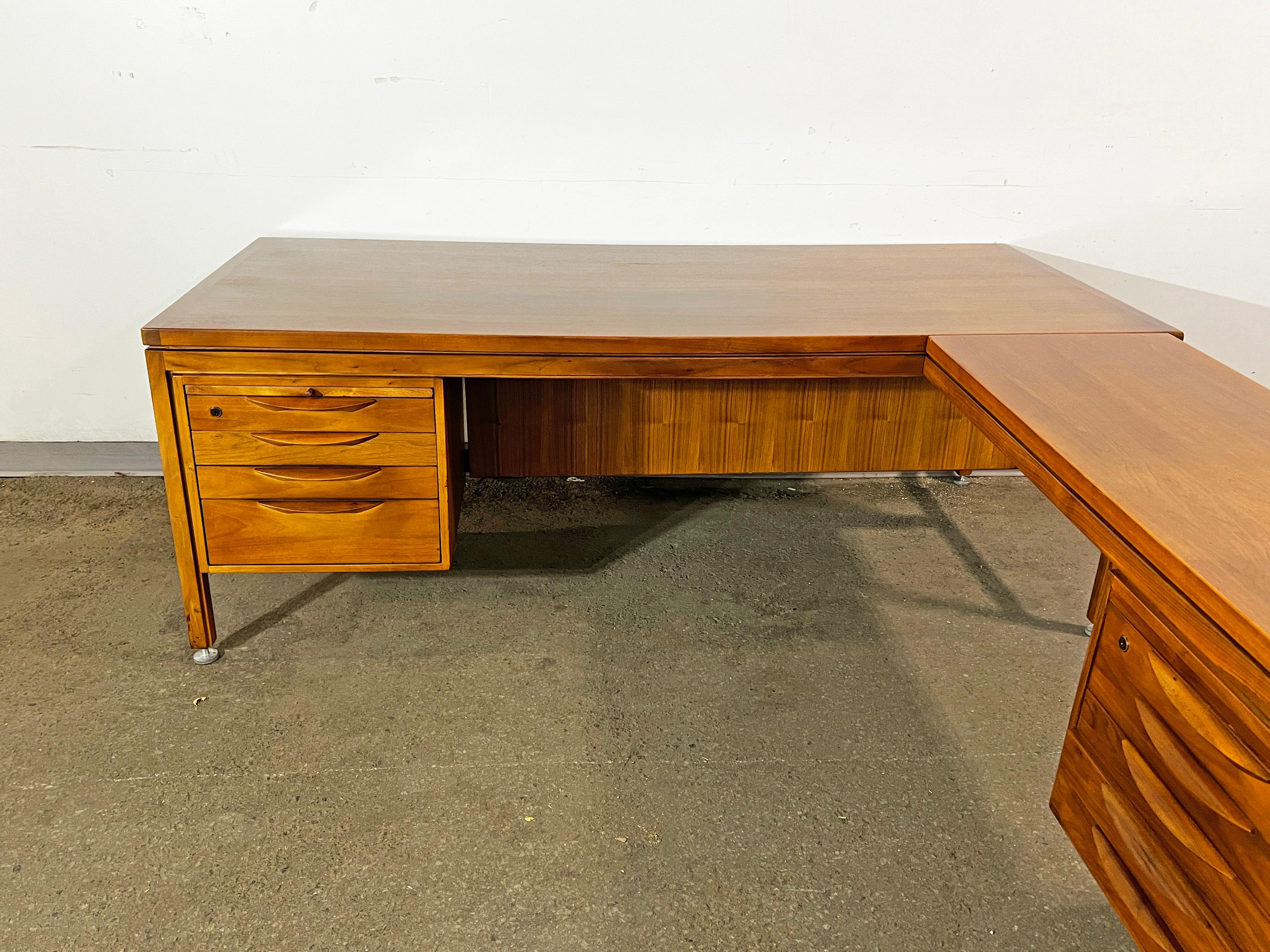 Large mid-century executive desk in walnut by Jens Risom, circa 1960s with storage drawers and a pull-out writing surface to left of sitter with glass insert.  Desk includes a return with extra storage and work space that mounts to right of the