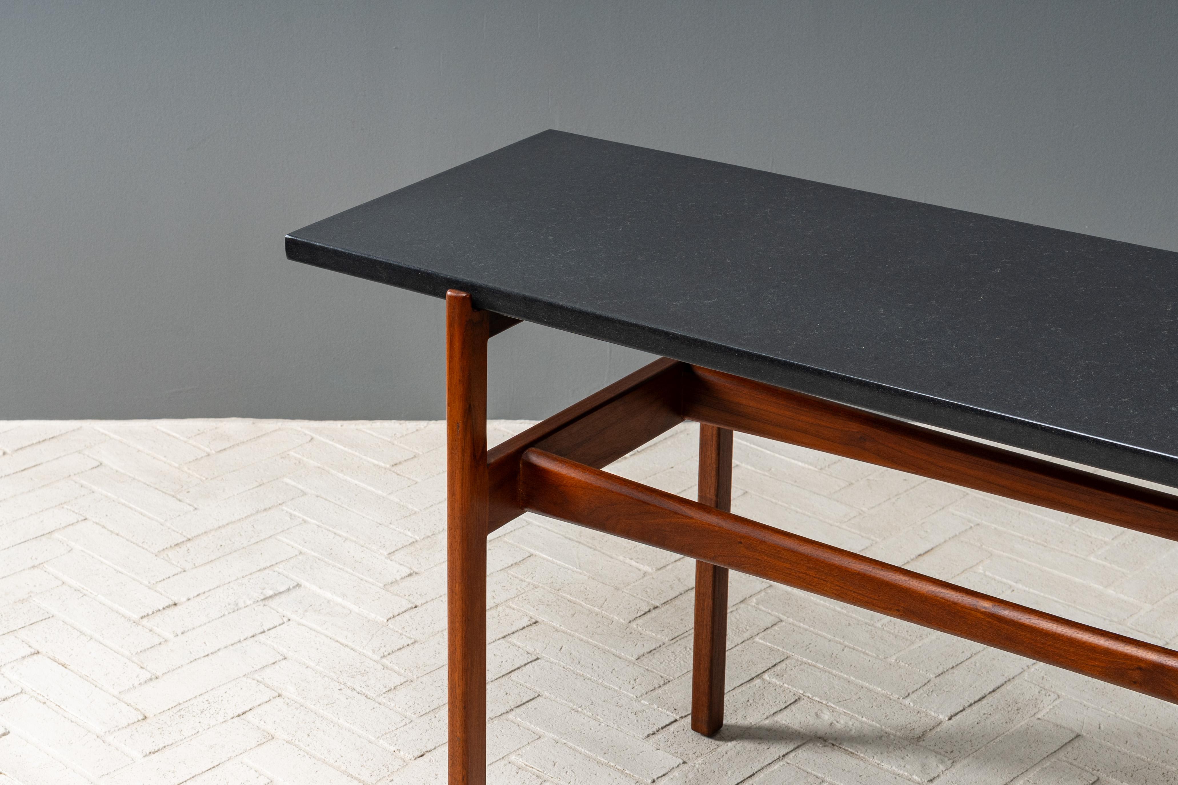 EE.UU., hacia la década de 1960. Una elegante consola rectangular de Jens Risom para Jens Risom Design. Presenta una encimera flotante de pizarra apoyada en una base de nogal macizo con esculturales camillas acampanadas. Perfecto para un recibidor,