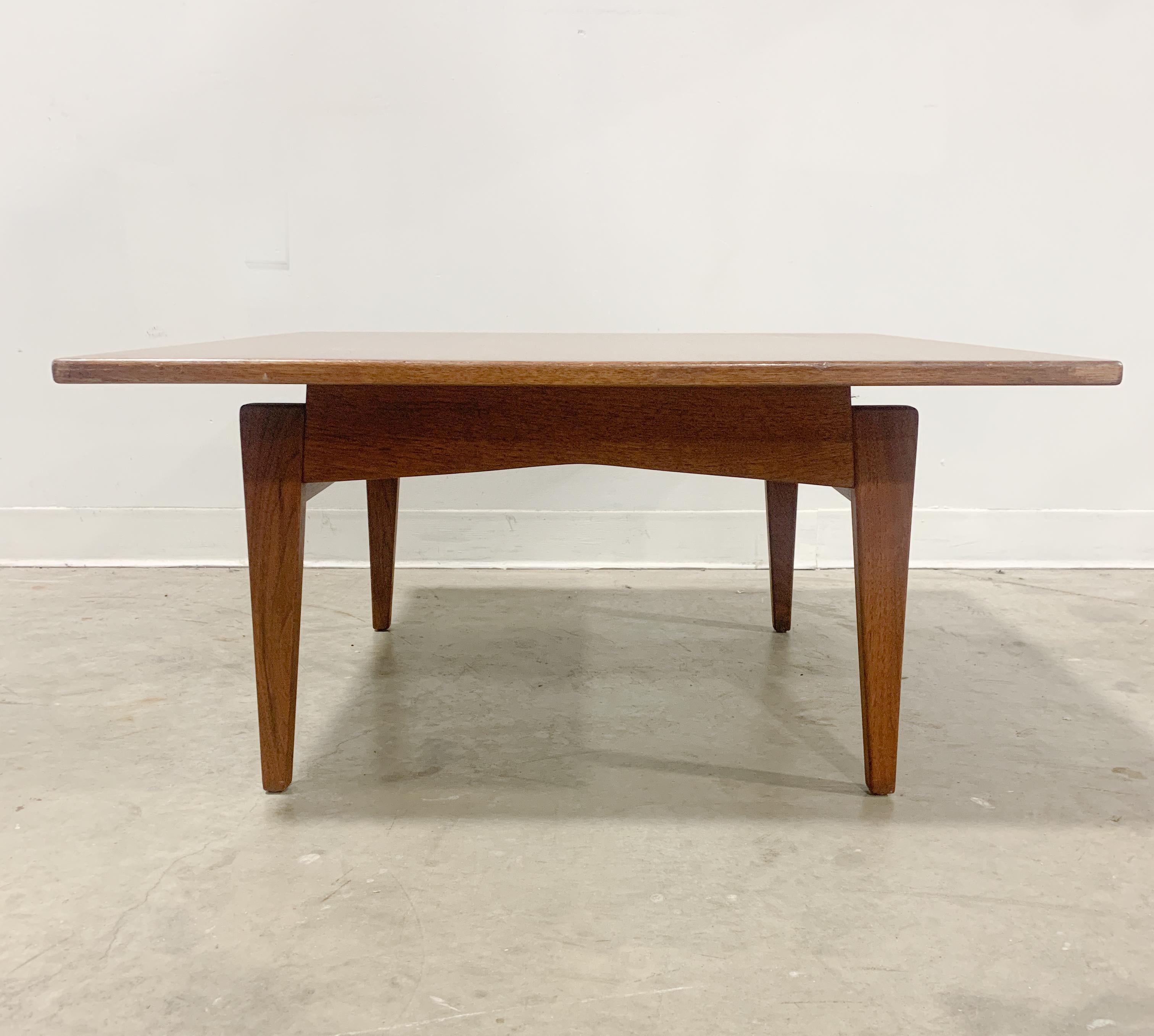 Beautiful solid walnut table designed by Jens Risom for his own company. Distinctive leg design and floating top make this table an eyecatcher. Label not present but you can see where a paper label was adhered underneath, excellent